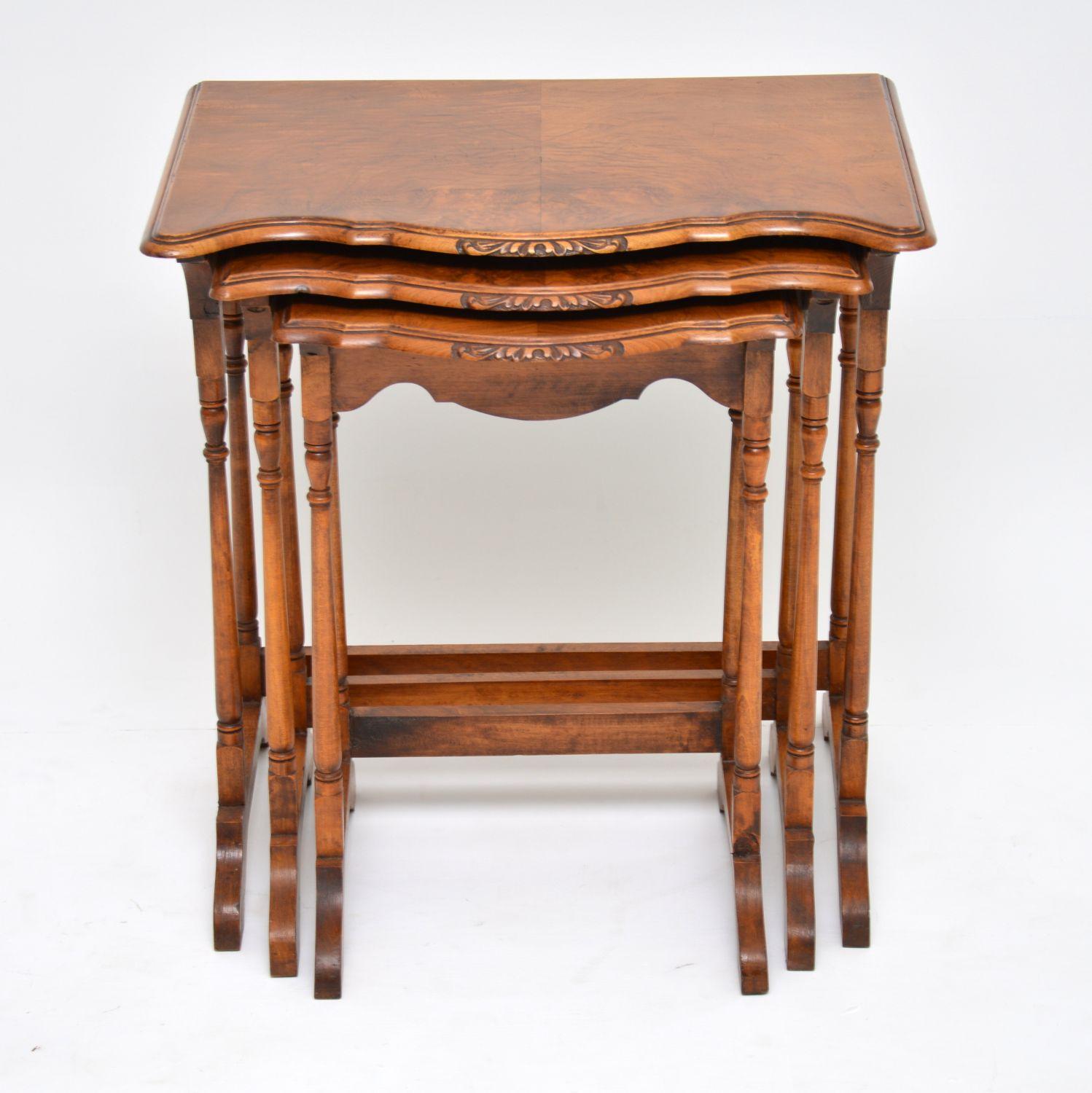 Antique walnut nest of tables dating from circa 1910s-1920s period and in excellent condition. They have burr walnut tops with well shaped fronts & Fine carving on the front edges. These tables have stretchers running between the back legs which all
