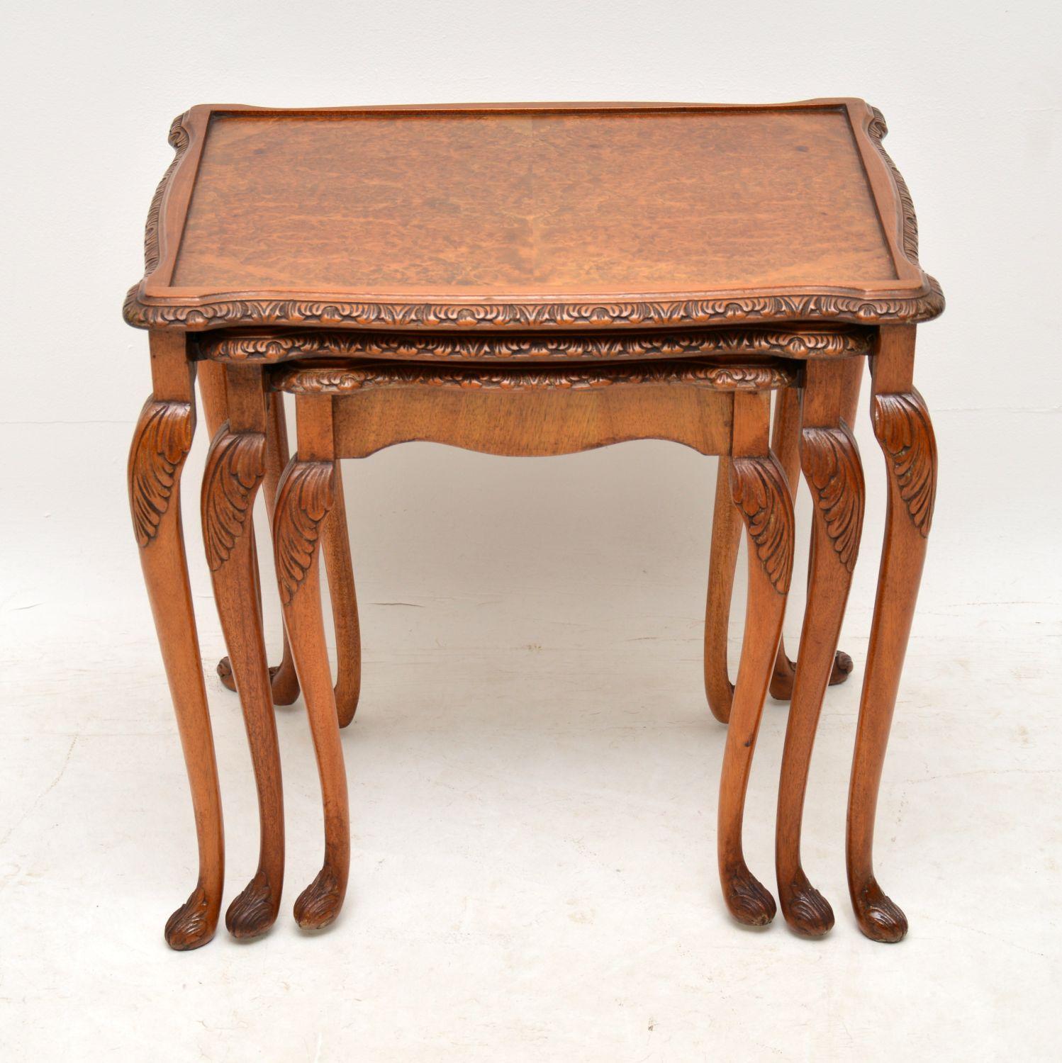 Antique Queen Anne style walnut nest of tables dating from circa 1930s period and in good original condition, having just been French polished. They have burr walnut table tops, carved shaped edges and more carving on the solid walnut