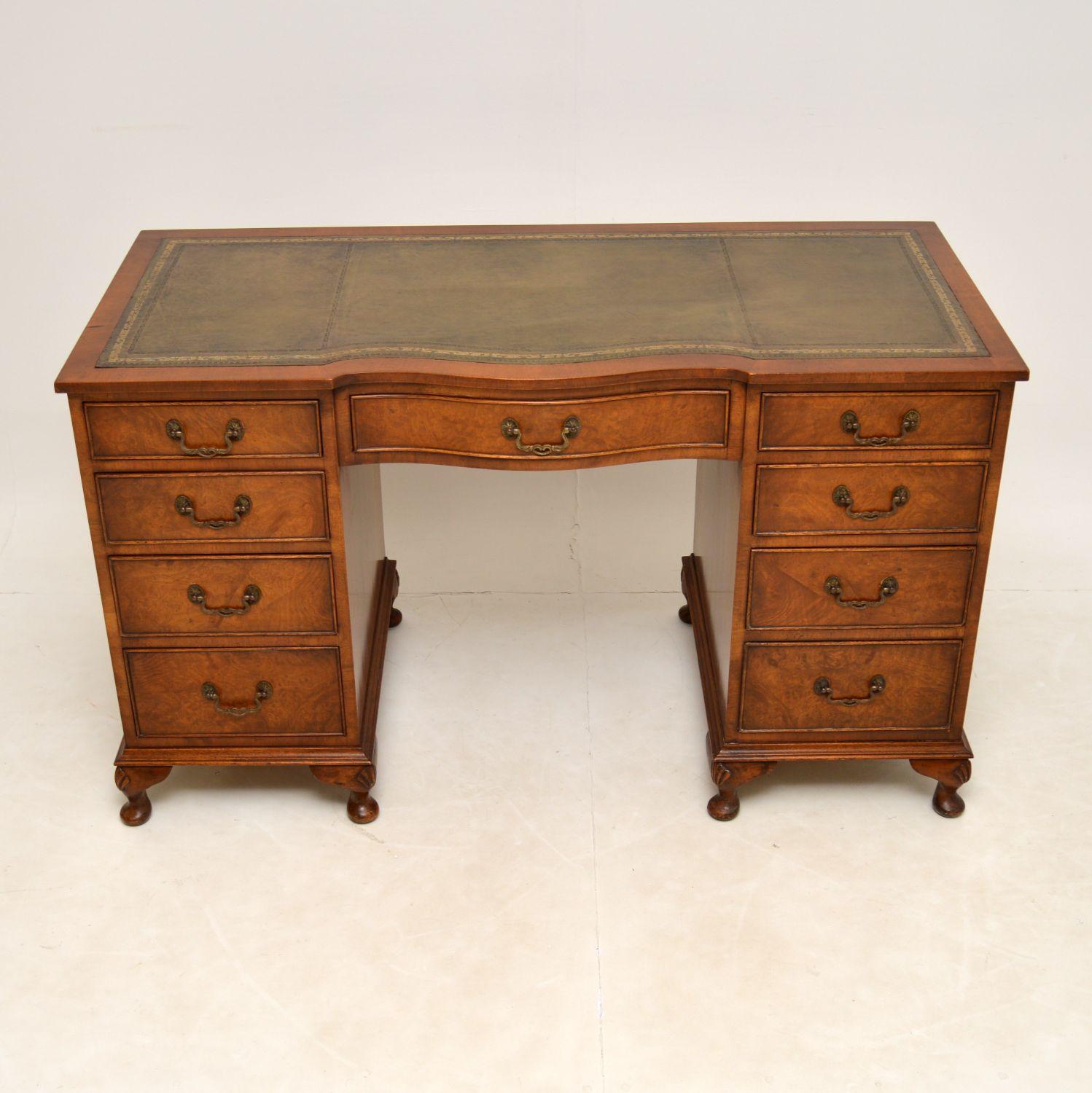 An excellent antique burr walnut desk with a leather writing surface & dating from around the 1930’s period.

It has a serpentine shaped front & the drawers are graduated in depth with original brass handles. The burr walnut side panels are