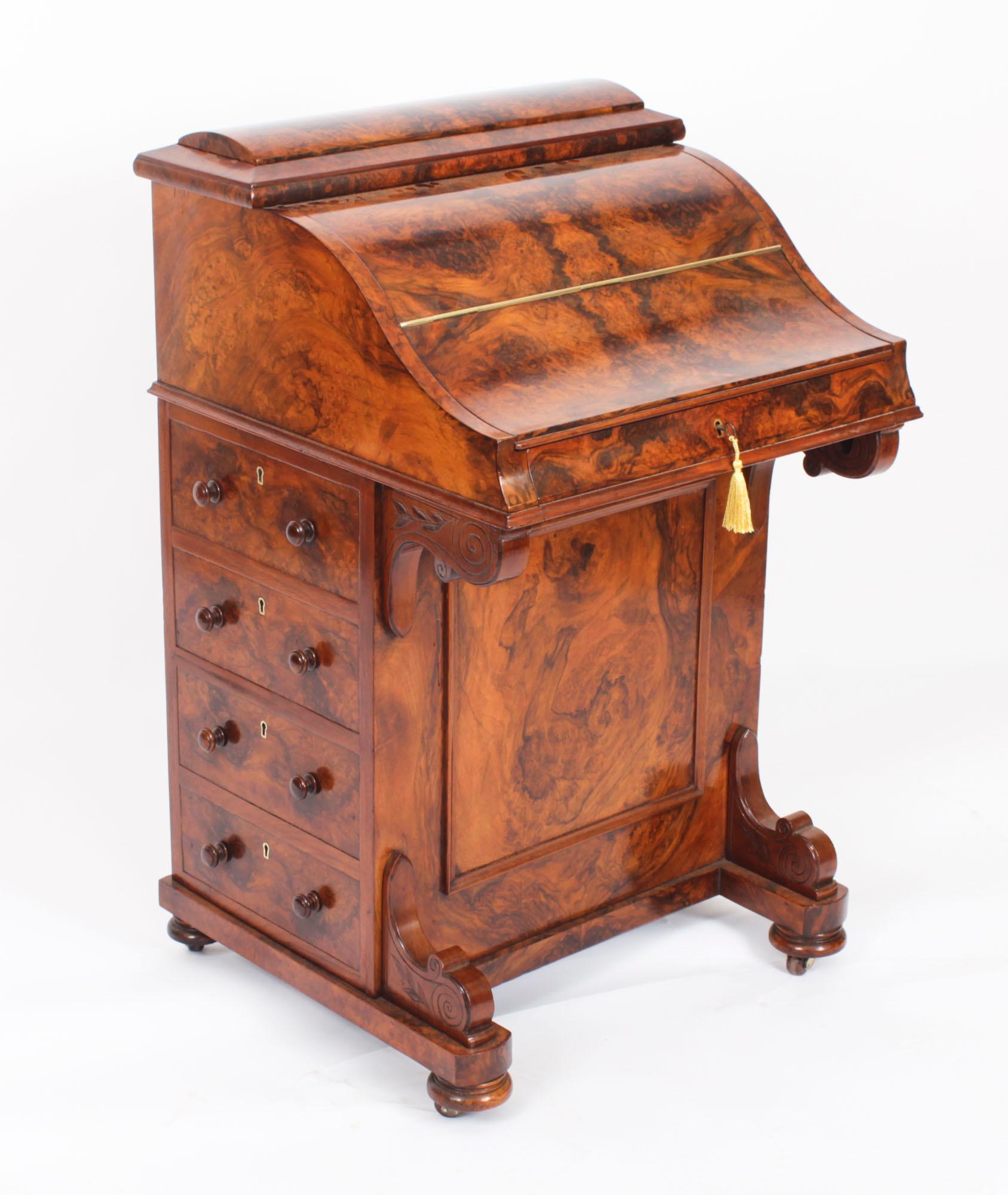 This is a gorgeous antique Victorian Davenport Desk crafted from beautiful burr walnut and circa 1860 in date.

The hinged 'piano' lid opening to reveal maple veneered drawers and a pull out writing slope with pen & ink compartments to one side and