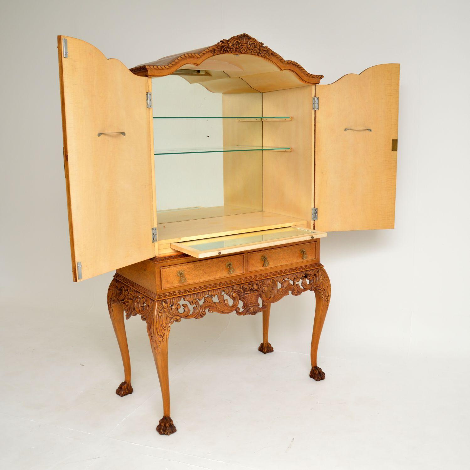 Excepcional mueble bar de estilo Queen Anne en nogal con rebabas. Fabricado en Inglaterra, data aproximadamente de los años 1920-30.

Es de una calidad asombrosa, con unas funciones extremadamente bellas y útiles.

Hay una fina talla floral en toda
