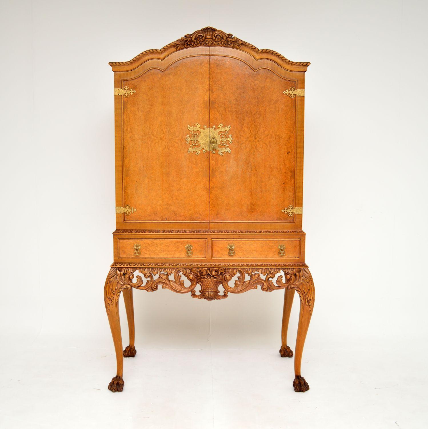 An exceptional antique burr walnut cocktail drinks cabinet in the Queen Anne style. This was made in England, it dates from around the 1920-30’s.

It is of amazing quality with some extremely beautiful and useful features.

There is fine floral
