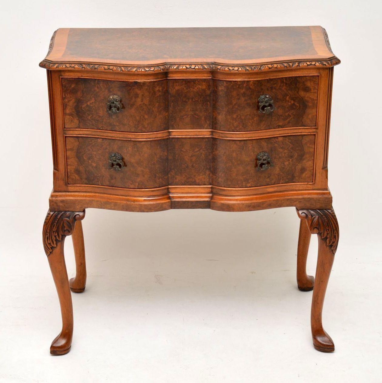 This antique burr walnut side table has two drawers, so I’m not sure whether to call is a chest or side table. It has a wonderful double serpentine shaped front. The top is burr walnut with a crossbanded border and the top edges are well carved. The