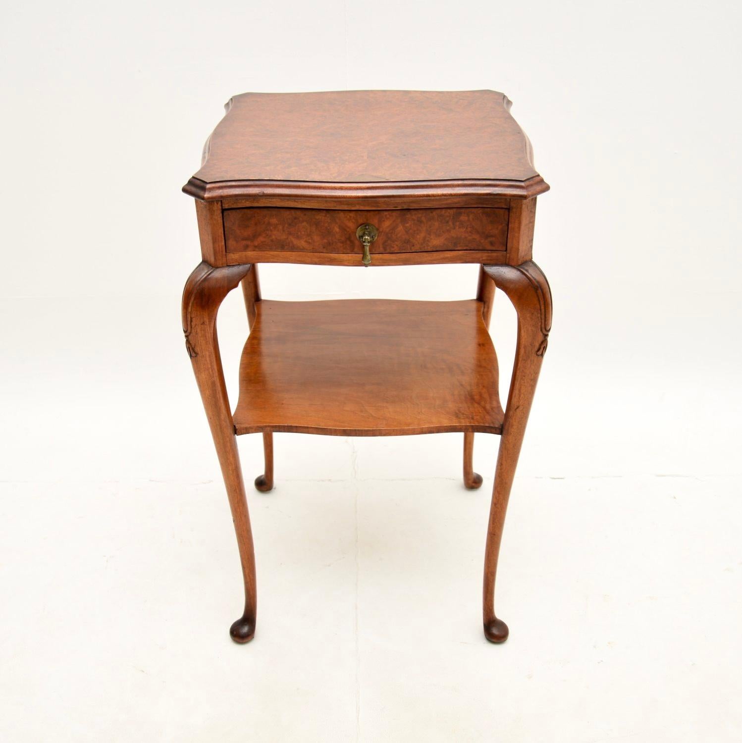 A lovely antique burr walnut two tier side table, made in England and dating from around the 1900-1920 period.

It is is of superb quality and is a very useful size to be used as an occasional side / lamp table around the home. It has beautifully