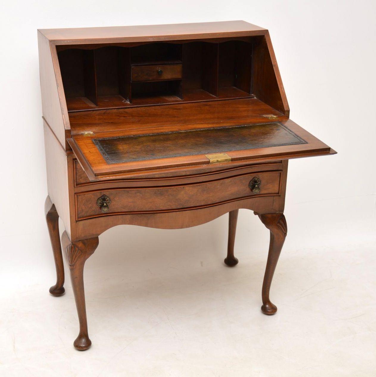 Antique Queen Anne style walnut bureau dating from the 1920s period & in excellent condition. The front section is burr walnut & the flap is crossbanded too. The two drawers are serpentine shaped & have original brass drop handles. The top & sides