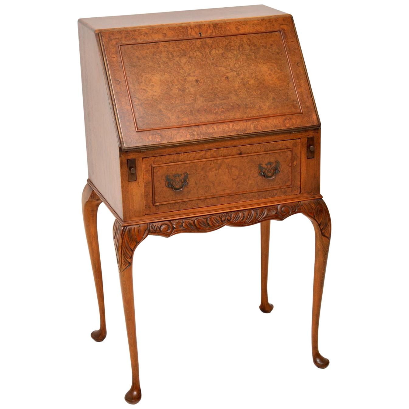 Small antique Queen Anne style burr walnut bureau in lovely condition with a nice warm color and dating from circa 1930s period. It has a pull down flap which rests on pull out loafers. The inside has a tooled leather writing surface with a single