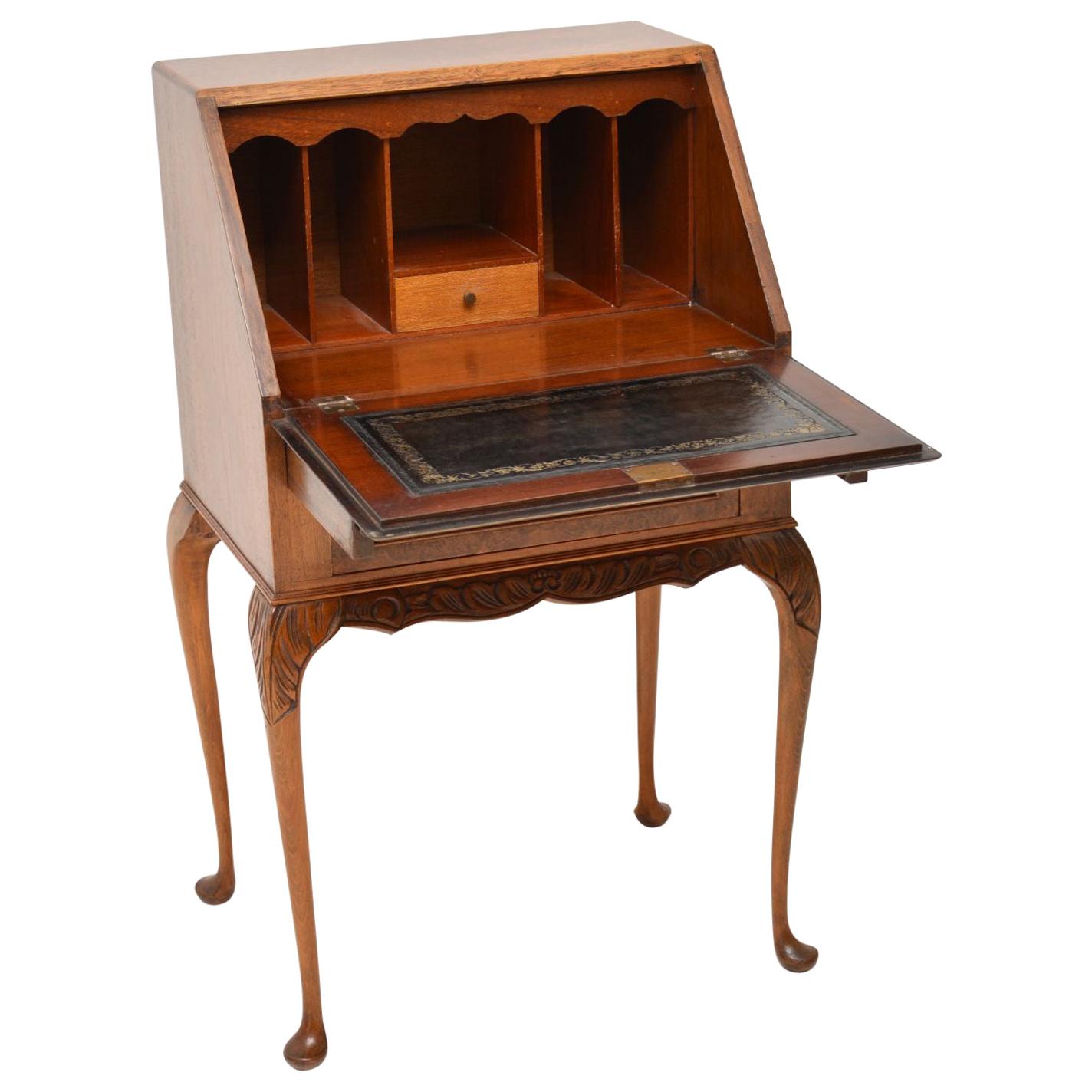 Small antique Queen Anne style burr walnut bureau in lovely condition with a nice warm color and dating from circa 1930s period. It has a pull down flap which rests on pullout / pull-out loafers. The inside has a tooled leather writing surface with