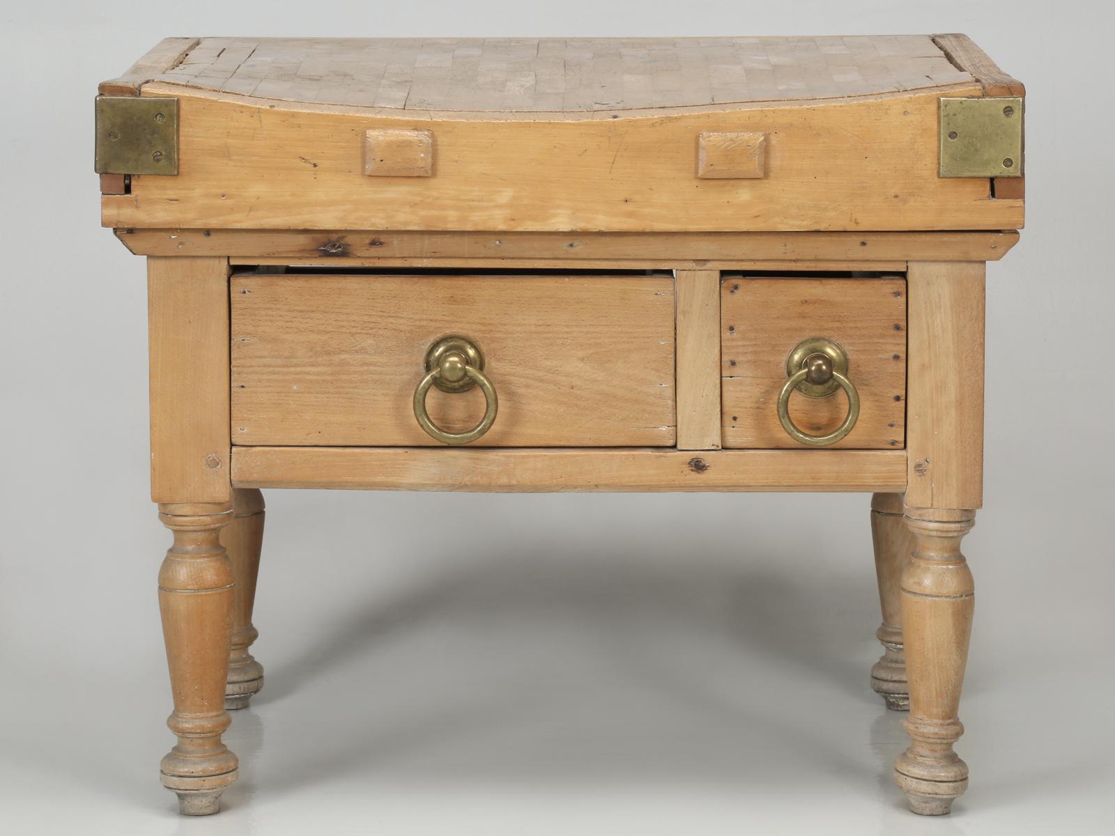 American antique butcher block was constructed from solid blocks of maple and still is adorned with its original solid brass hardware, dovetailed top and wooden-peg constructed legs. This American antique butcher block has been in the owner's