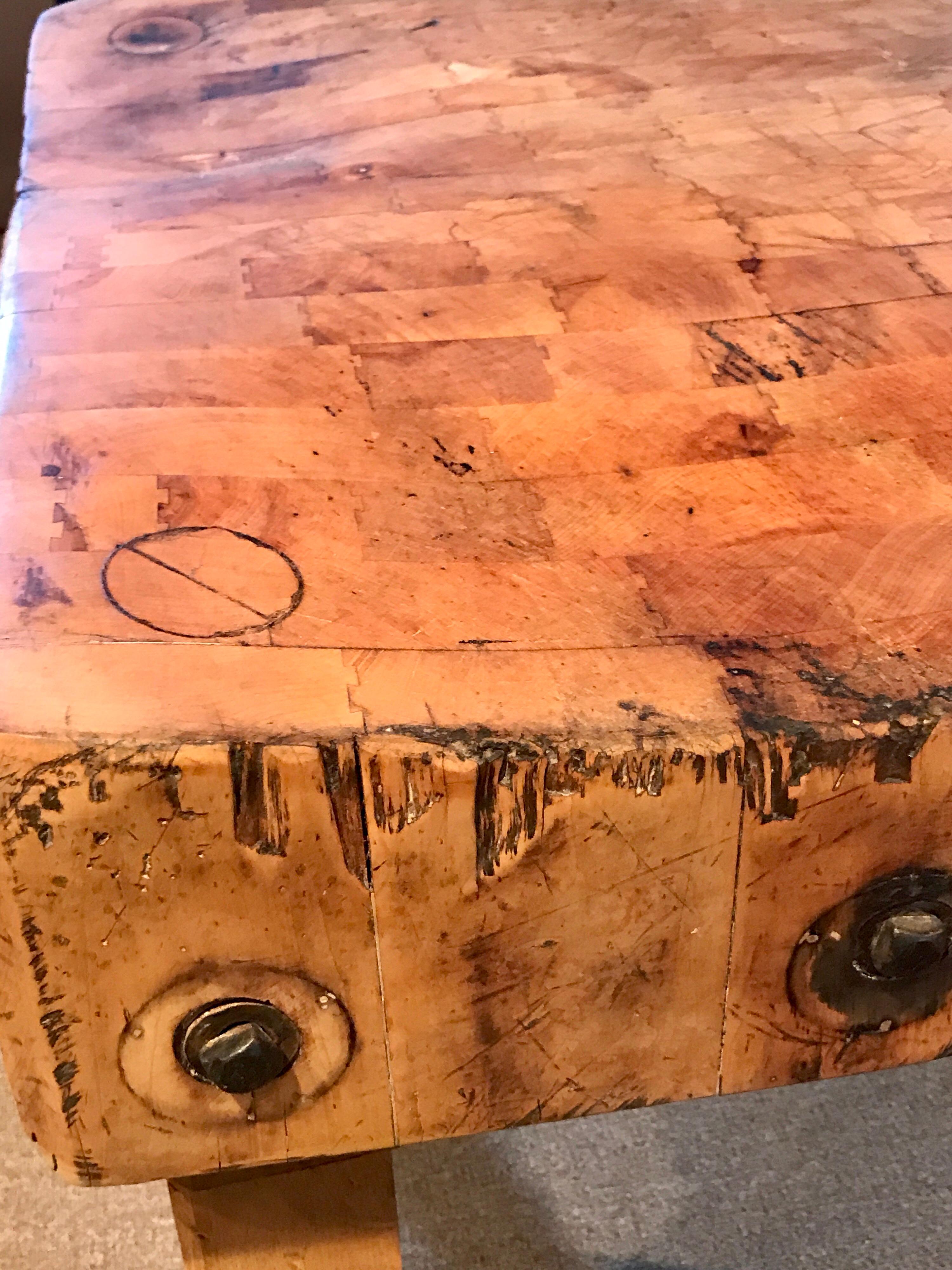 Antique butcher block table, 7-Inches thick. Great size and shape. Beautiful distressed condition, structurally sound, ready for use. Secured and sturdy, the legs are not removable.