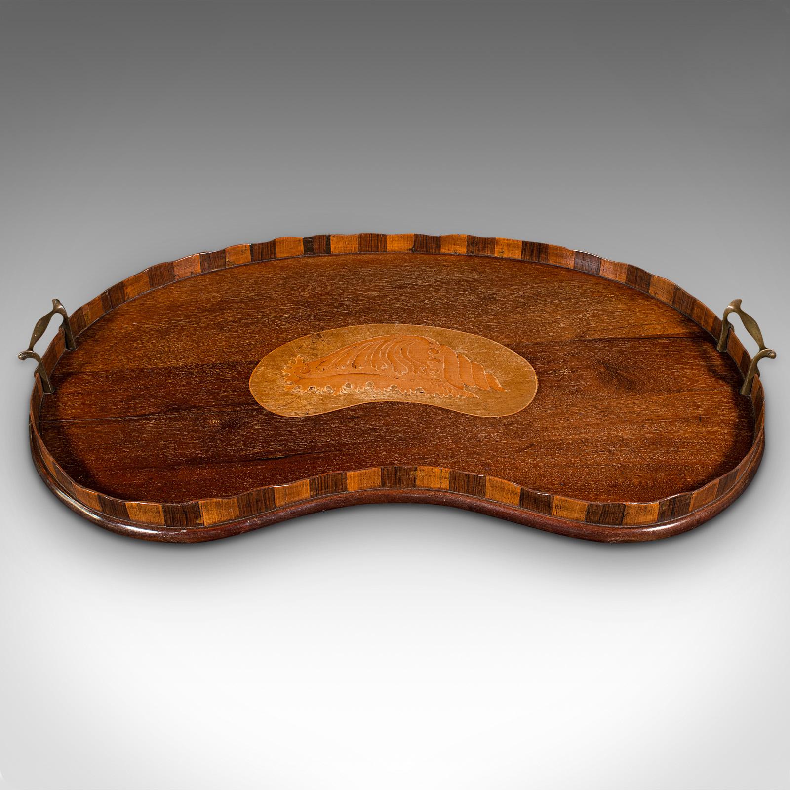 This is an antique butler's serving tray. An English, mahogany and walnut afternoon tea platter with boxwood inlay, dating to the Regency period, circa 1820.

Fascinating kidney shaped tray with delightful quality and appearance.
Displays a