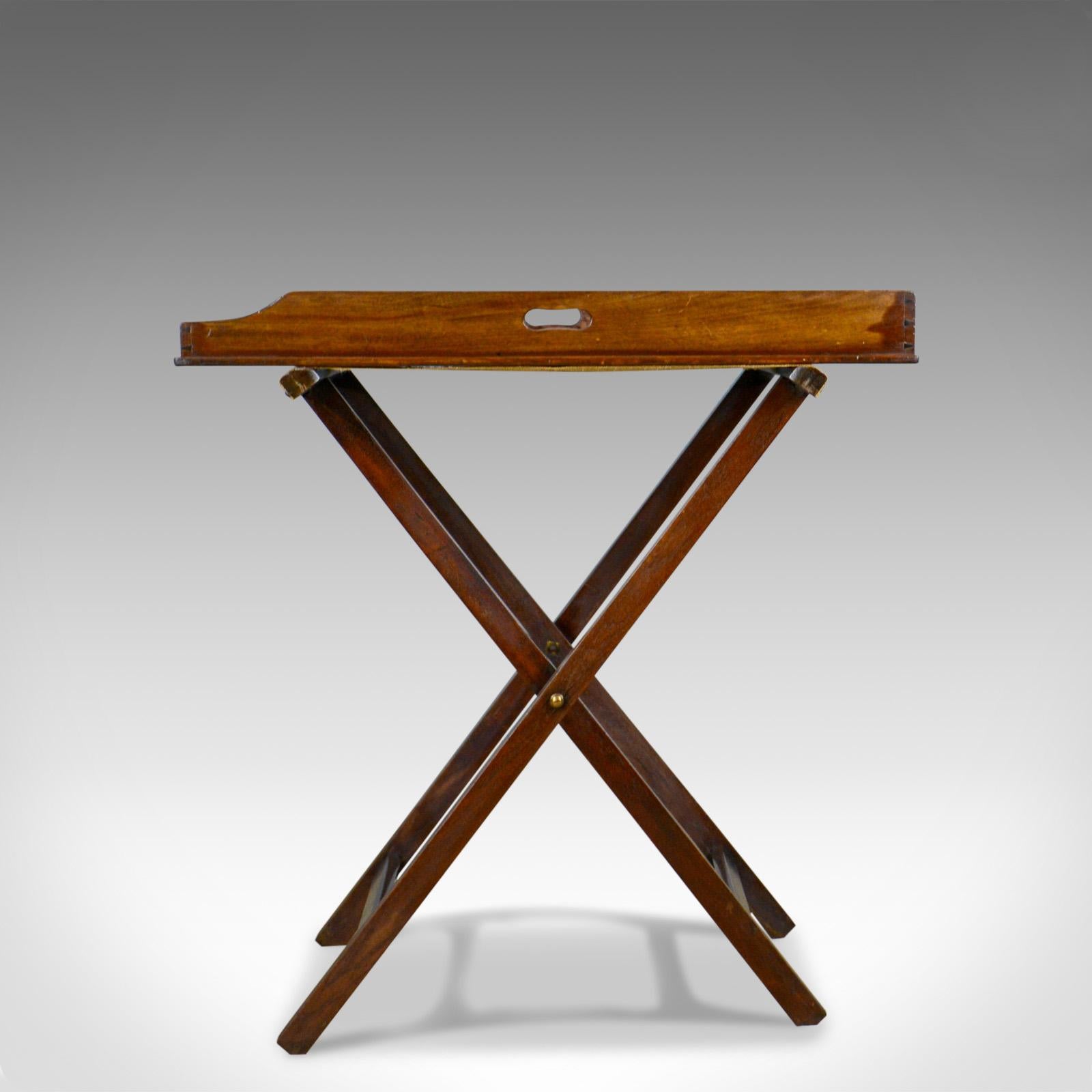This is an antique butler's tray table, an English, mahogany tray on folding stand dating to the early 20th century, circa 1900.

In good order with delightful color and tone
Grain interest in the wax polished finish
Easily folds up for carrying