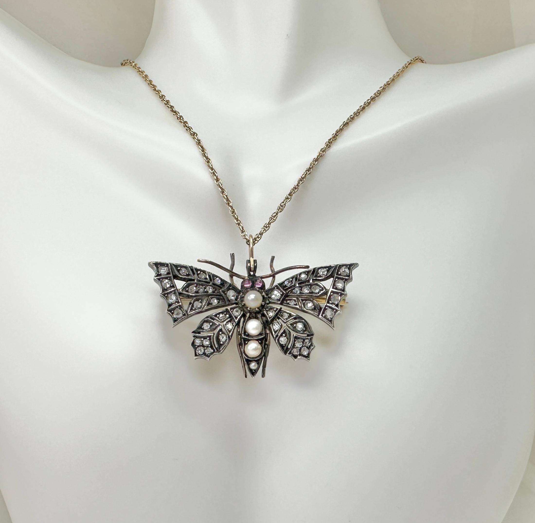 This is a spectacular antique Victorian - Belle Epoque Butterfly Pendant or Brooch set throughout with Rose Cut Diamonds, Pearls and Rubies in a gorgeous open work design in Silver atop 14 Karat Yellow Gold.  This is one of the most beautiful