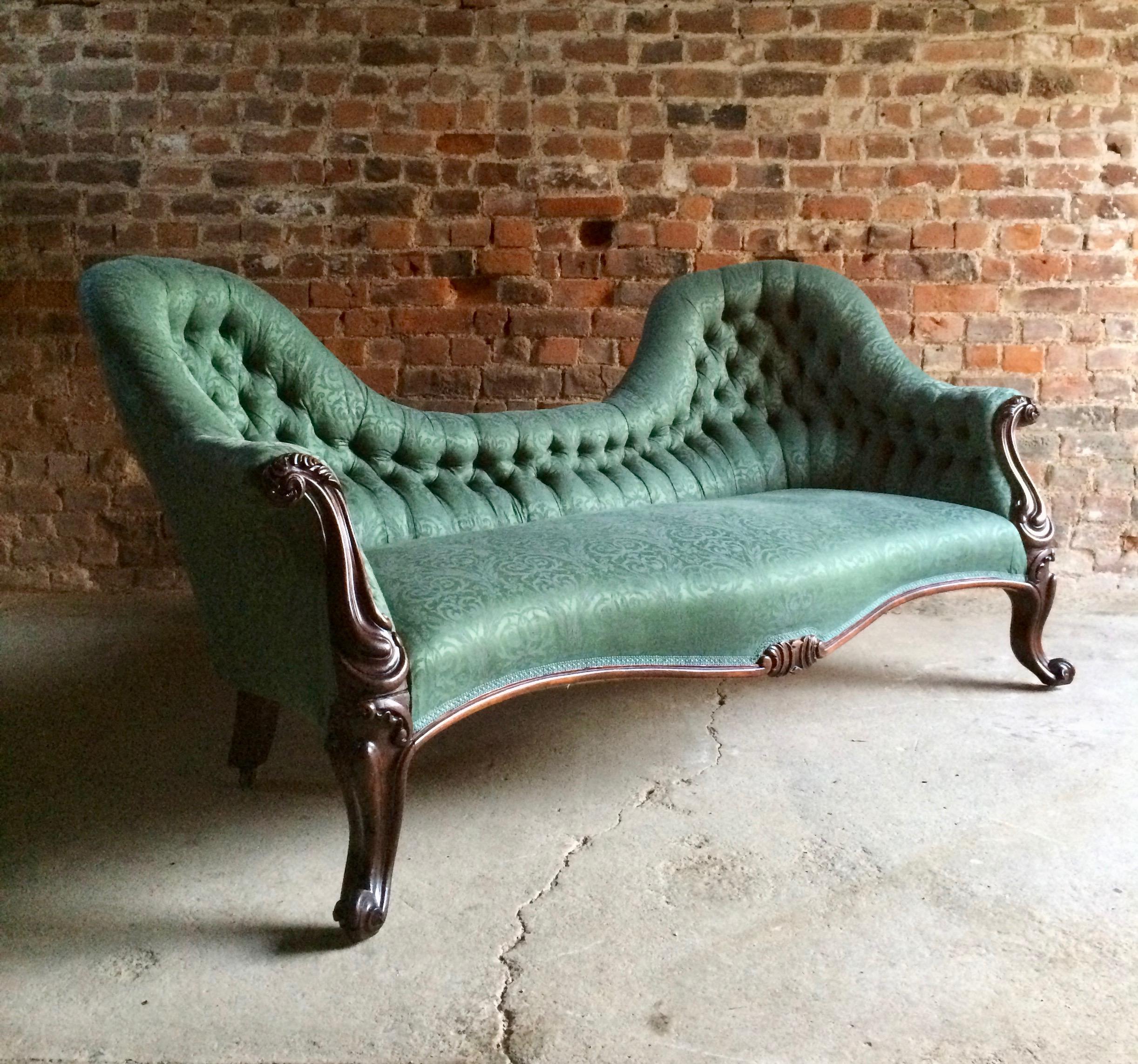 A magnificent Victorian button back inverted Camel back sofa circa 1870, having recently been re upholstered in a wonderful green damask pattern fabric, with carved rosewood frame, on scrolling feet and brass casters, together with a matching