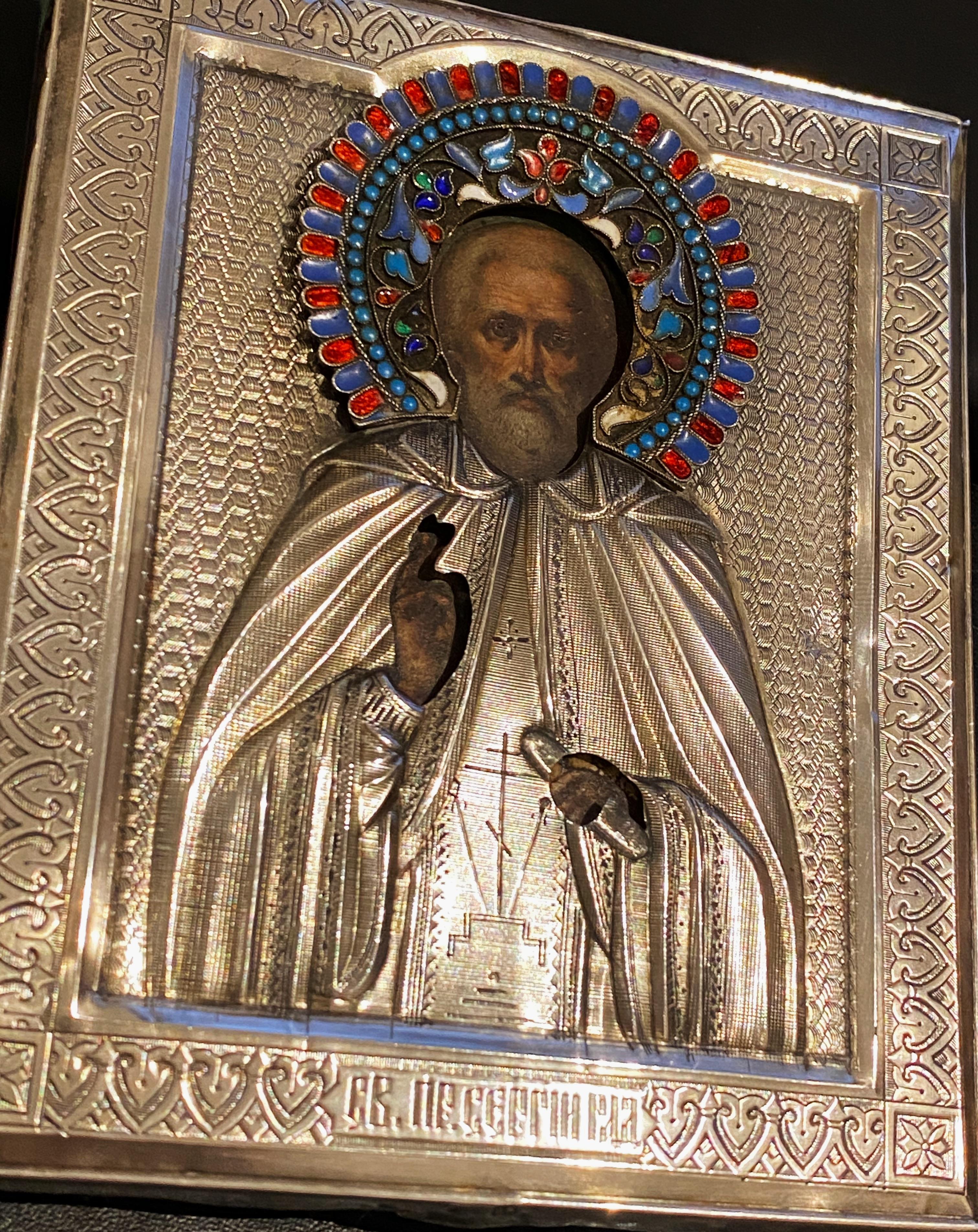Questa antica Icona russa del 1899 circa
raffigura San Sergej,
con un'aureola colorata e finemente dettagliata in smalto cloisonné.
(in viola e porpora, blu cielo e indaco, rosso rubino, turchese, bianco e verde) 
& 84 argento oklad / riza,