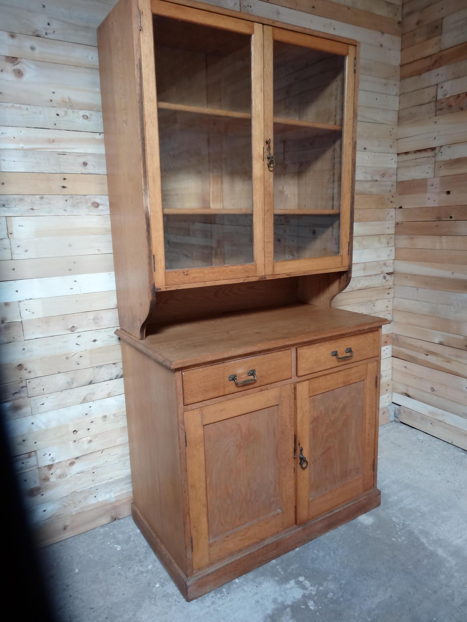 Antique Ca 1900 solid light oak English kitchen cabinet,

Lovely solid oak cabinet in super condition, it has bottom shelving cupboard with two drawers en two doors and a top glazed display section, comes with the original key.

Measures: Height