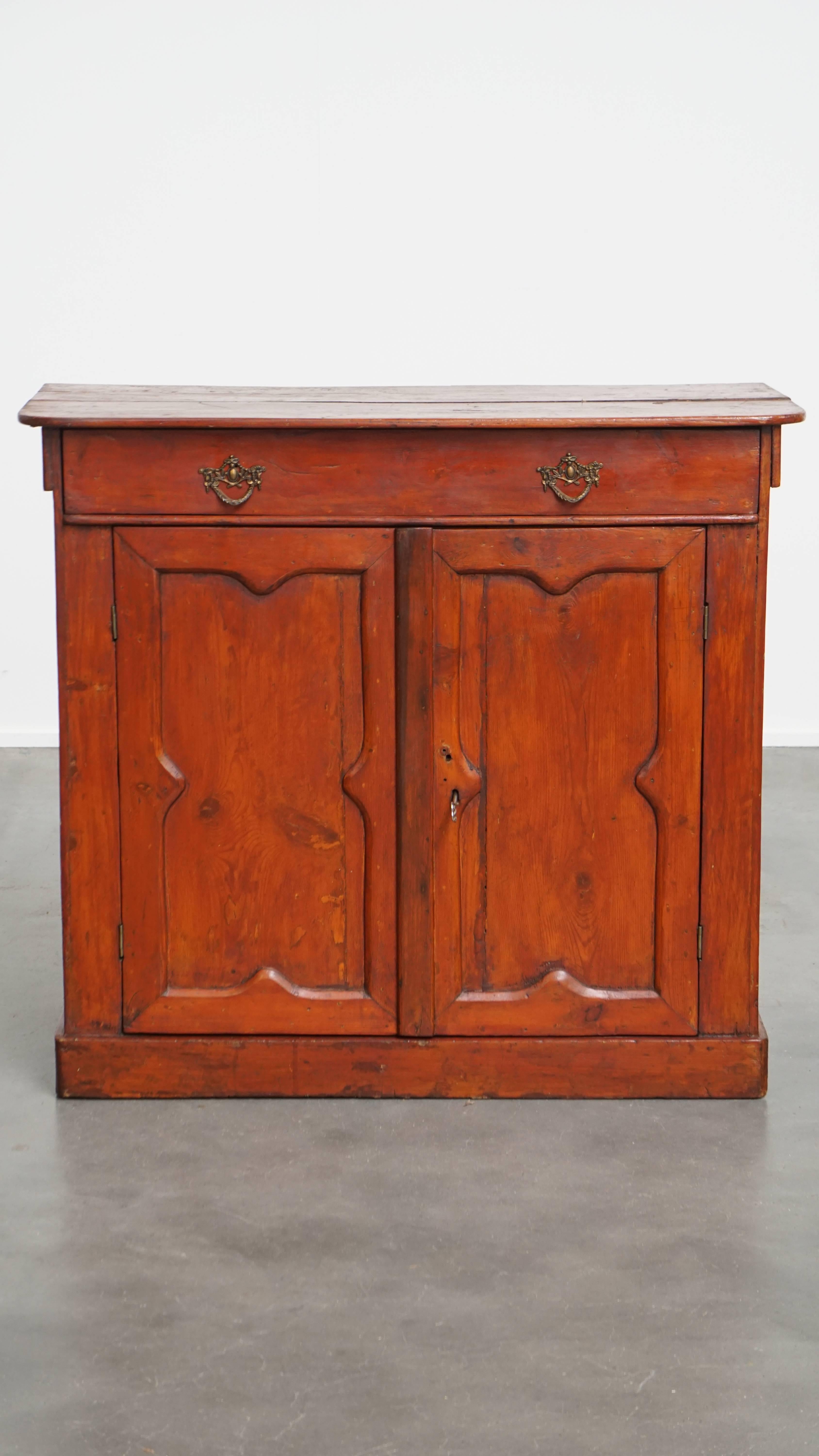 Offered here this beautiful antique cabinet in a red/brown color with 2 doors and a drawer with a working lock.
This charming antique cabinet fits easily into almost any interior. It features a warm red/brown hue and comes with 2 doors and a drawer