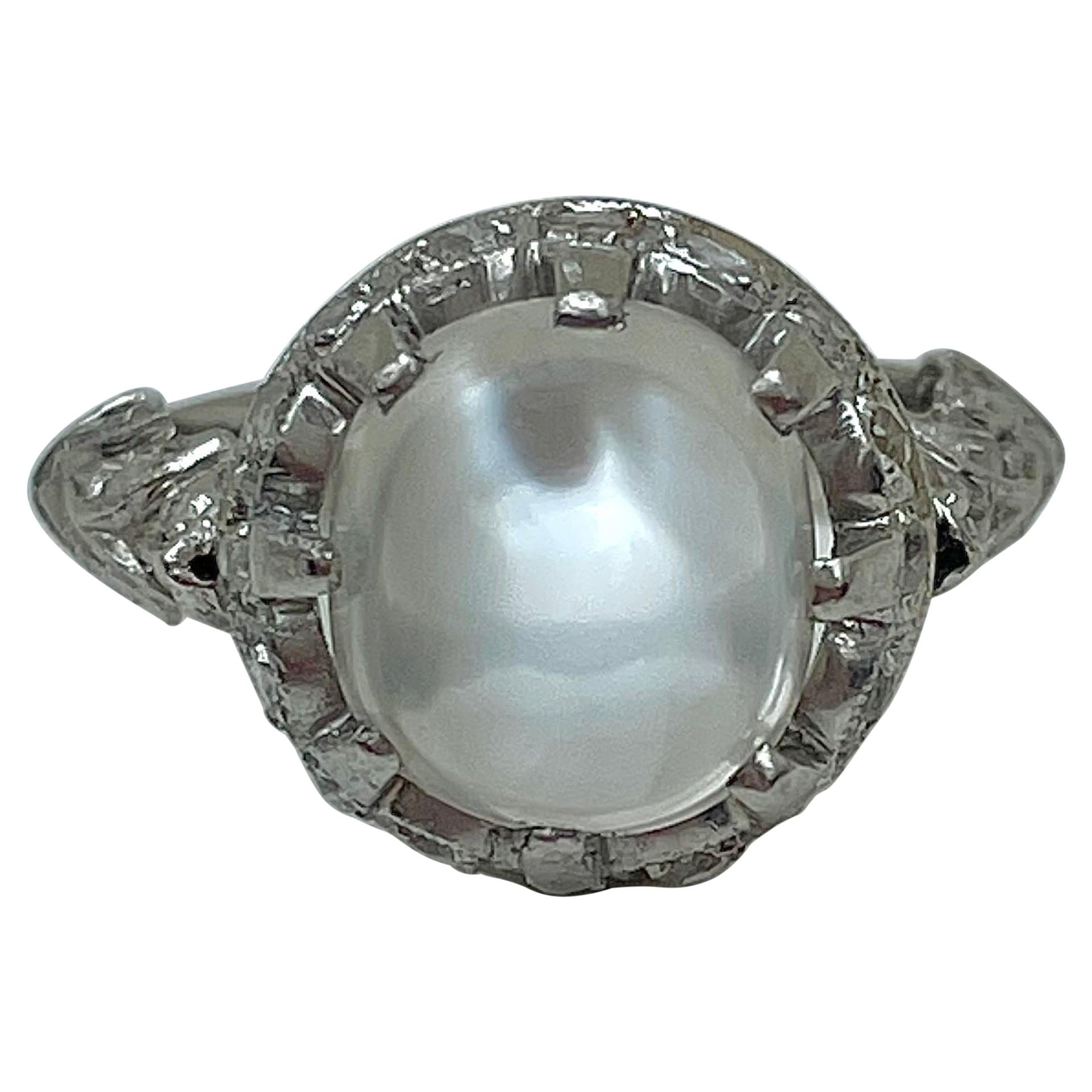 Anello antico con pietra lunare cabochon e diamanti in oro bianco