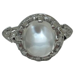 Anello antico con pietra lunare cabochon e diamanti in oro bianco