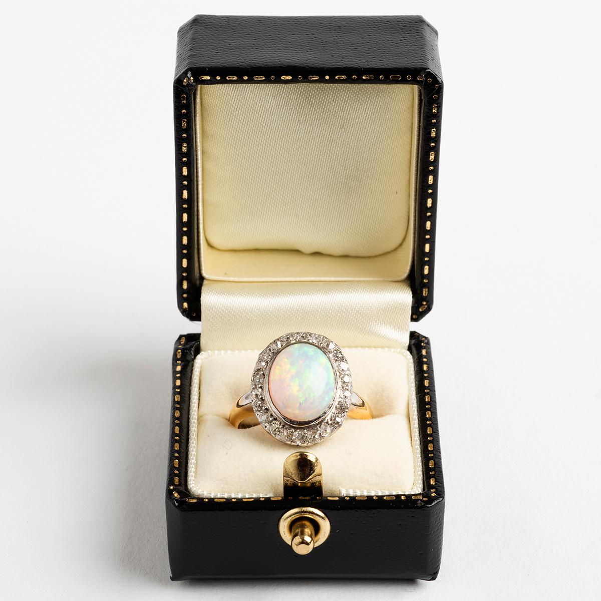Our antique opal cabochon with diamond cluster ring is set in platinum and 18k gold. A stunning and quality stone, in a beautiful setting , which adds vintage charm to any collection. The ring size is M.

A unique piece within our carefully curated