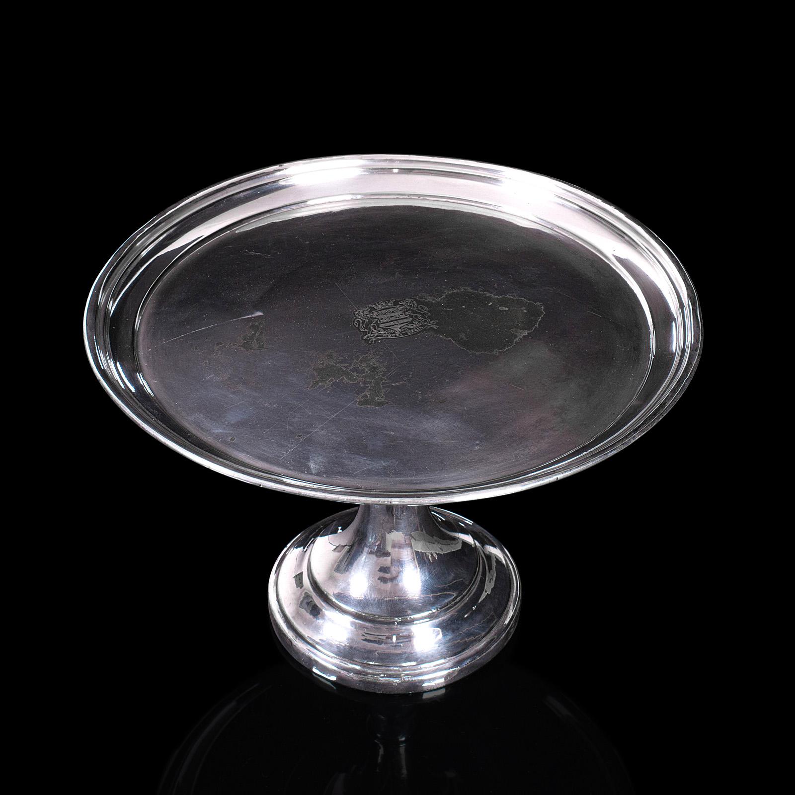 This is an antique cake stand. An English, silver plated serving dish with engraved Cecil Hotel, London emblem, dating to the late Victorian period, circa 1900.

Elegant cake stand ideal for special occasions
Displays a desirable aged patina with