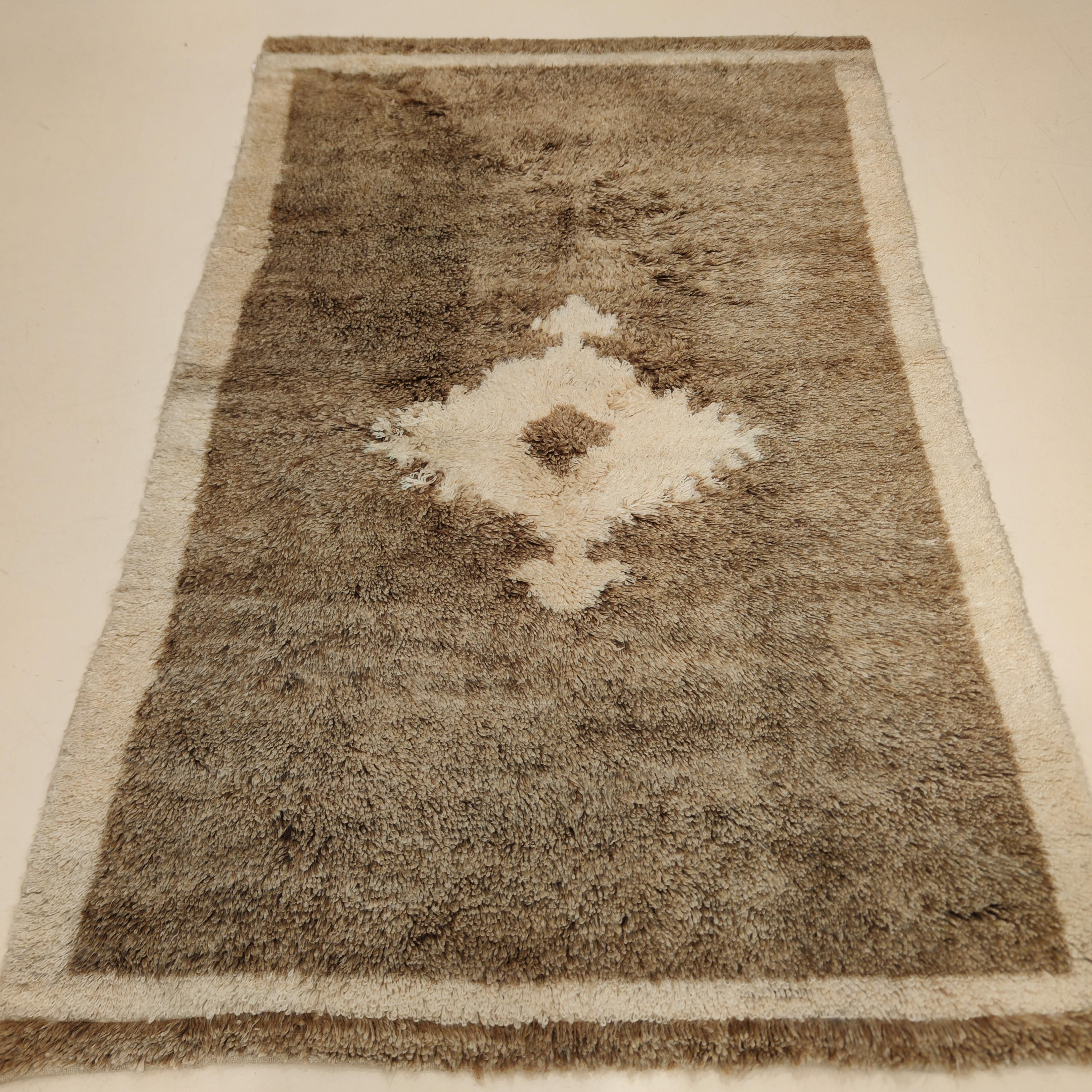 A rare and early Tulu woven using the finest Angora wool, resulting in a finely woven rug with a silky texture and a blanket-like handle. The soft camel field is embellished by a zoomorphic central device similar to some motifs founds in Neolithic