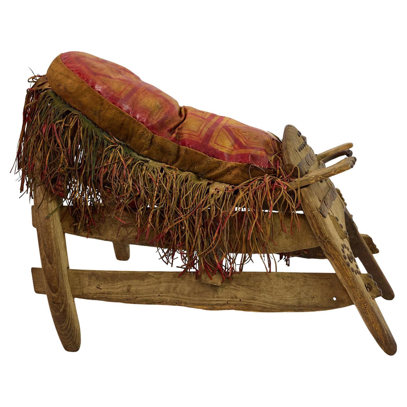 This is an exceptional example of a tribal ceremonial camel saddle, likely originating from North Africa or the Middle East, dating to the late 19th or early 20th century.
The saddle exhibits masterful traditional craftsmanship with its sculptural