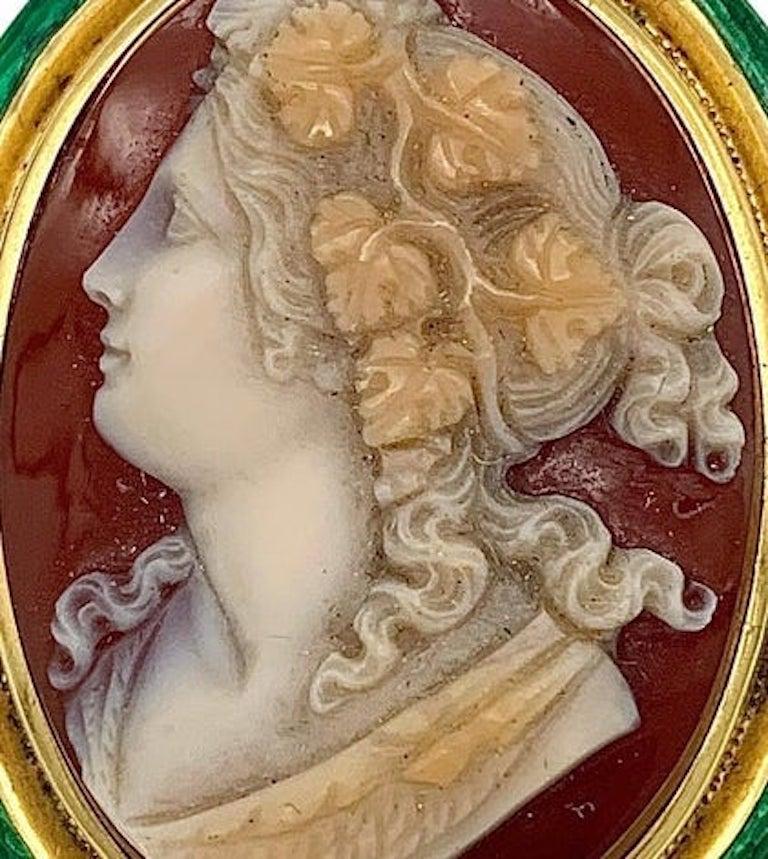 This sardonyx cameo of a bacchante, in Greek mythology a follower of Dyonisos, is monted in a gold brooch decorated with a guilloché enamelled frame.
The carving dates from the middle of the nineteenth century.  