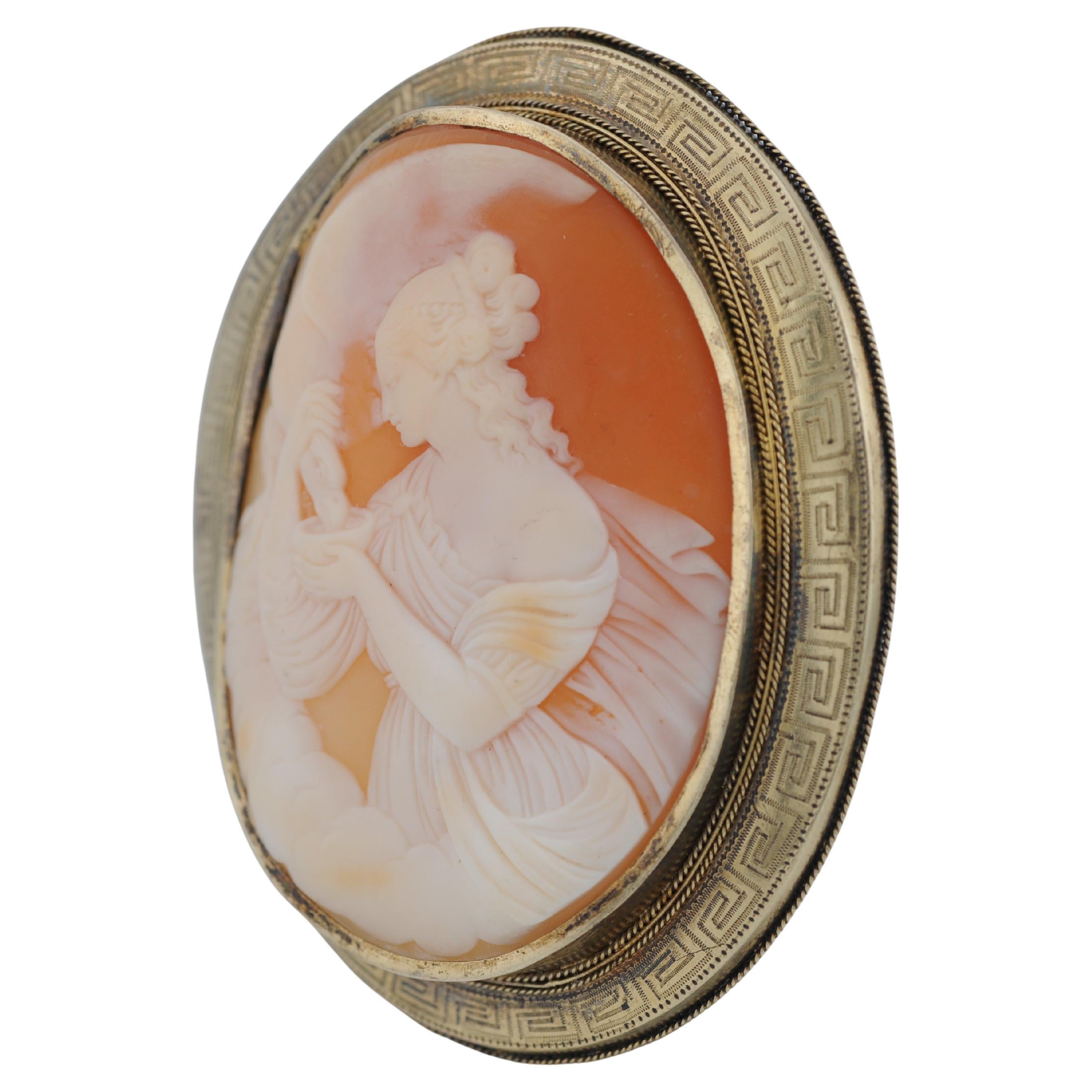 Bellissimo cammeo antico, incastonato in oro giallo 14K con accenti d'argento e dettagli delicati. Il motivo intagliato a mano raffigura una giovane donna che offre da bere a un'aquila da una ciotola. Un pezzo finemente realizzato e affascinante con