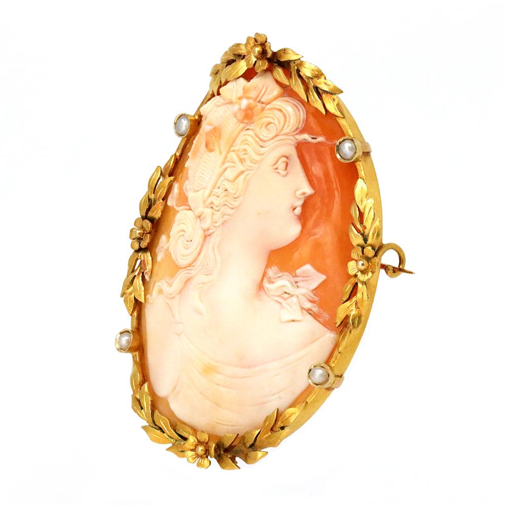 An impressive and well carved Antique Italian cameo brooch circa 1900. The elaborated and fine carving cameo represents the graceful profile of a woman. The bezel is set in 18 karat yellow with delicate floral motif accented with natural seed
