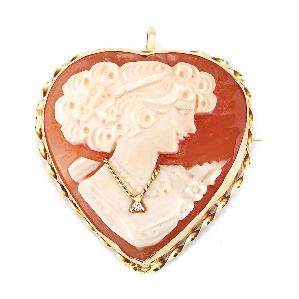 This antique cameo heart with diamond pin is made of 14K yellow gold. It contains a round diamond weighing 0.01 CTTW.