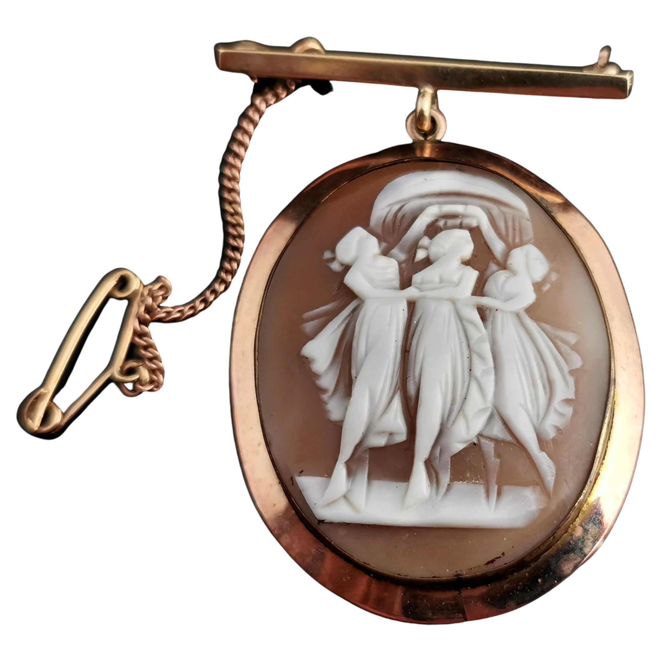 An attractive antique Edwardian era 9kt gold cameo pendant brooch.

A carved bullmou shell cameo depicting the three graces housed in a 9kt yellow gold frame, to the reverse there is a glazed compartment which currently holds an old photograph.

The
