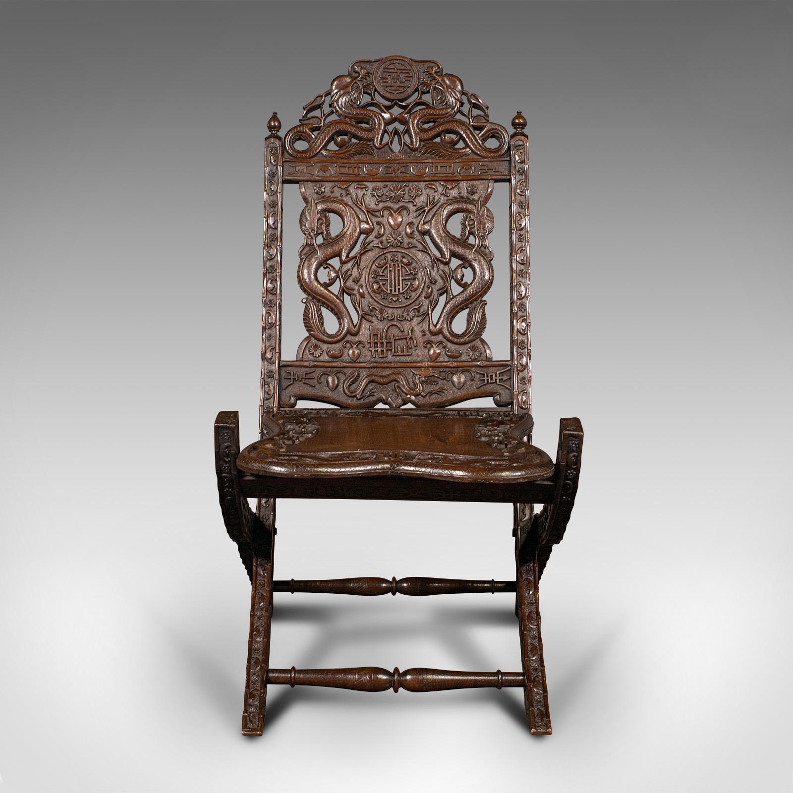 This is an antique campaign chair. A Chinese, carved mahogany folding colonial seat, dating to the early Victorian period, circa 1850.

Superb, decorative campaign chair, with strong 19th century Oriental taste
Displays a desirable aged patina