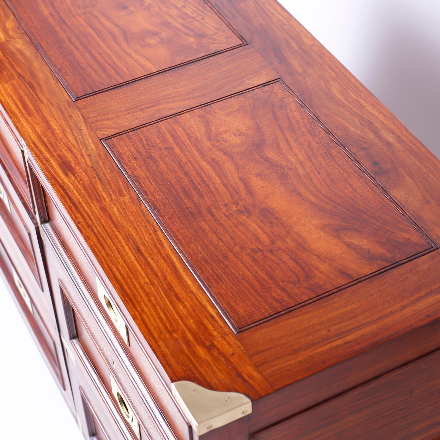 Intriguing rosewood chest with four drawers and a cabinet door featuring floral string brass inlays, paneled sides, campaign brass hardware and turned feet. Signed M. Hyatt & bros. in a drawer.