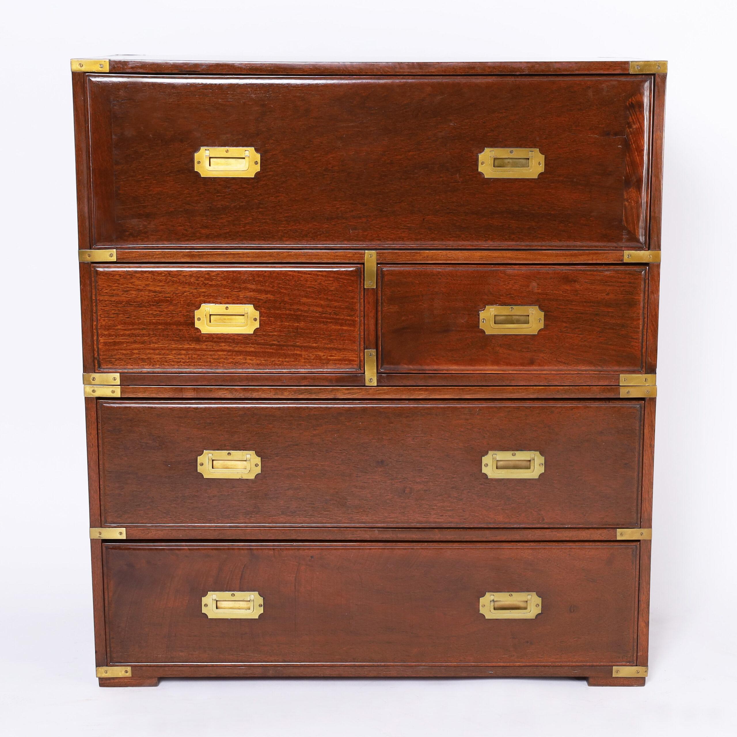 Impressive antique British Colonial Chinese campaign chest crafted in teak wood in two piece construction with brass hardware, featuring a unique pullout desk ambitiously crafted with nooks and drawers above four drawers on block feet.