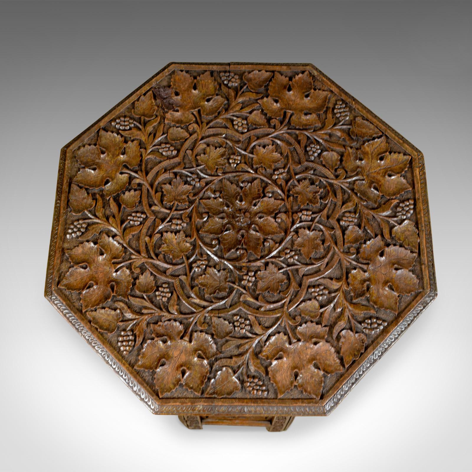 This is an antique campaign table, a beautifully carved, Anglo-Indian, teak side table dating to the turn of the century, circa 1900.

Profusely carved in deep relief
Fruit and foliate detail to the octagonal top
Pierced detailing to folding