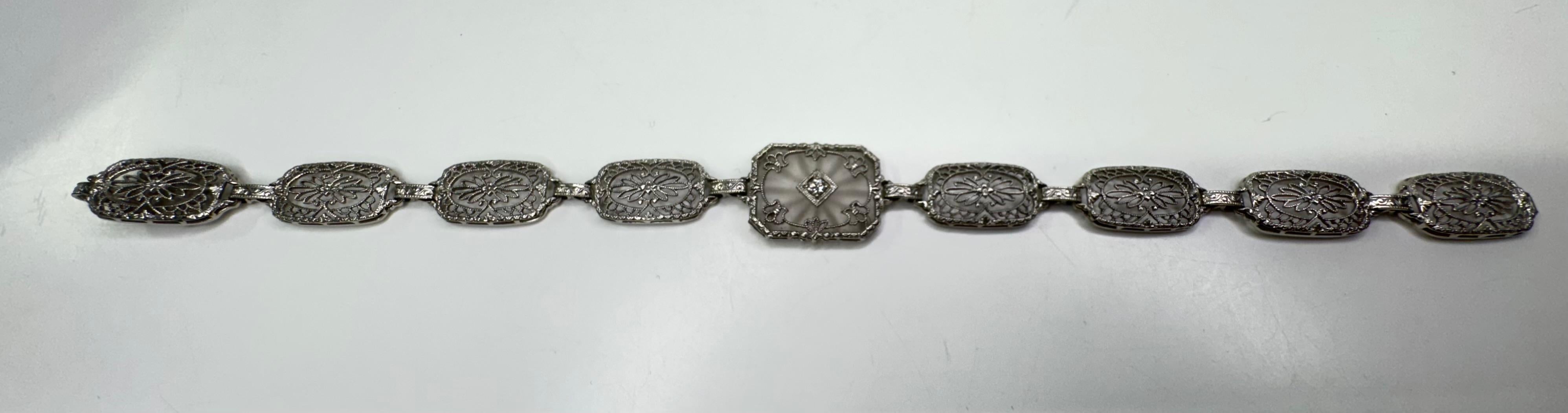 This exquisite antique bracelet showcases the timeless beauty of camphor glass set in an intricate 14k white gold filigree design. A true statement of vintage elegance, this piece features delicate detailing that highlights the craftsmanship of a