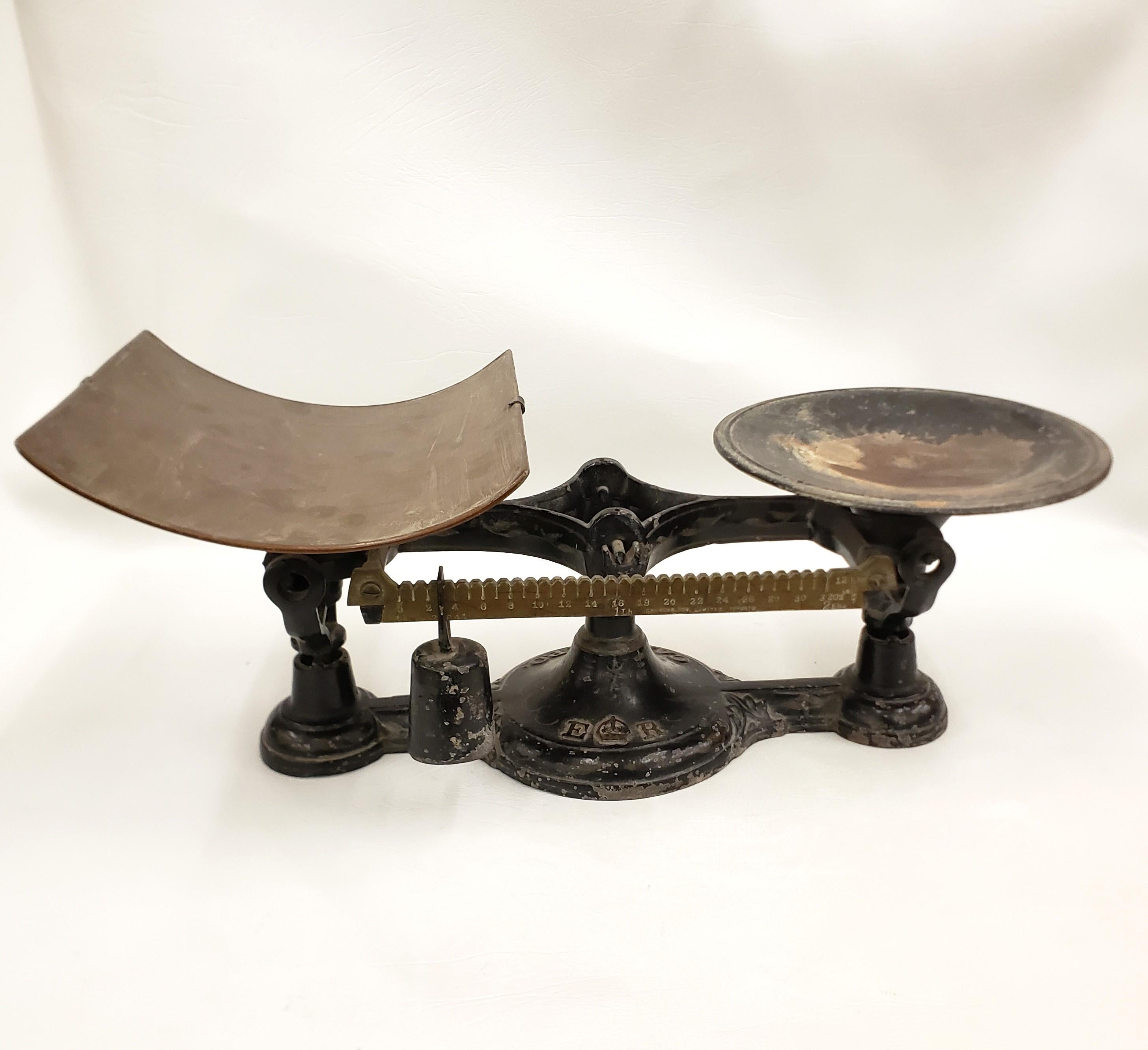This antique postal scale is unsigned, but presumed to have originated from Canada and date to approximately 1952 and done in the Late Victorian style. The scale is composed of cast metal with a brass pan and slide scale. The base has been