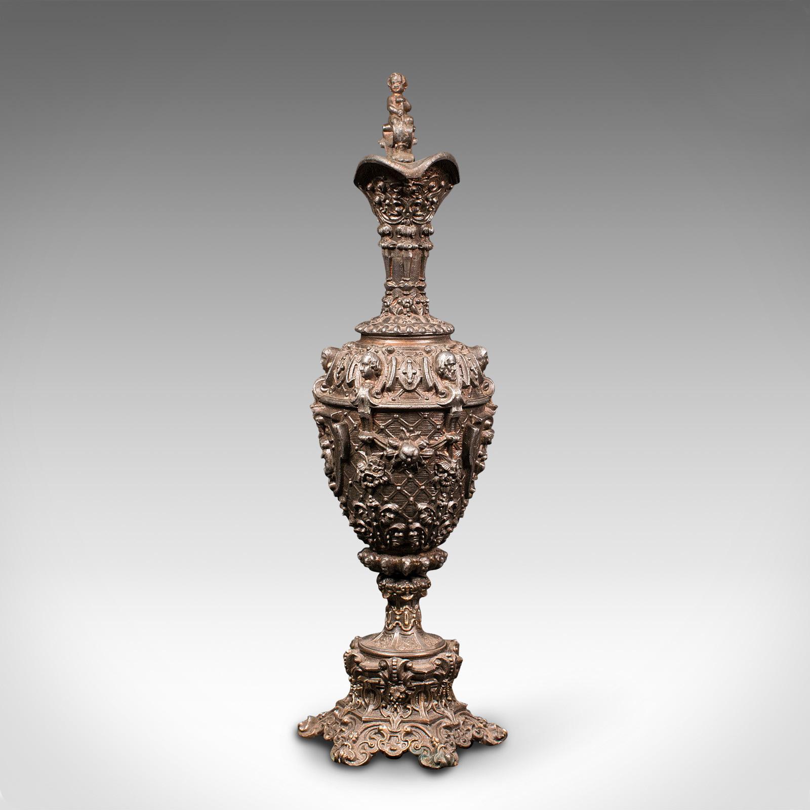 This is an antique candelabra. A French, bronze spelter candlestick in the form of a serving ewer, dating to the Victorian period, circa 1900.

Profusely decorative candelabra with great tonality
Displaying a desirably aged patina and in good