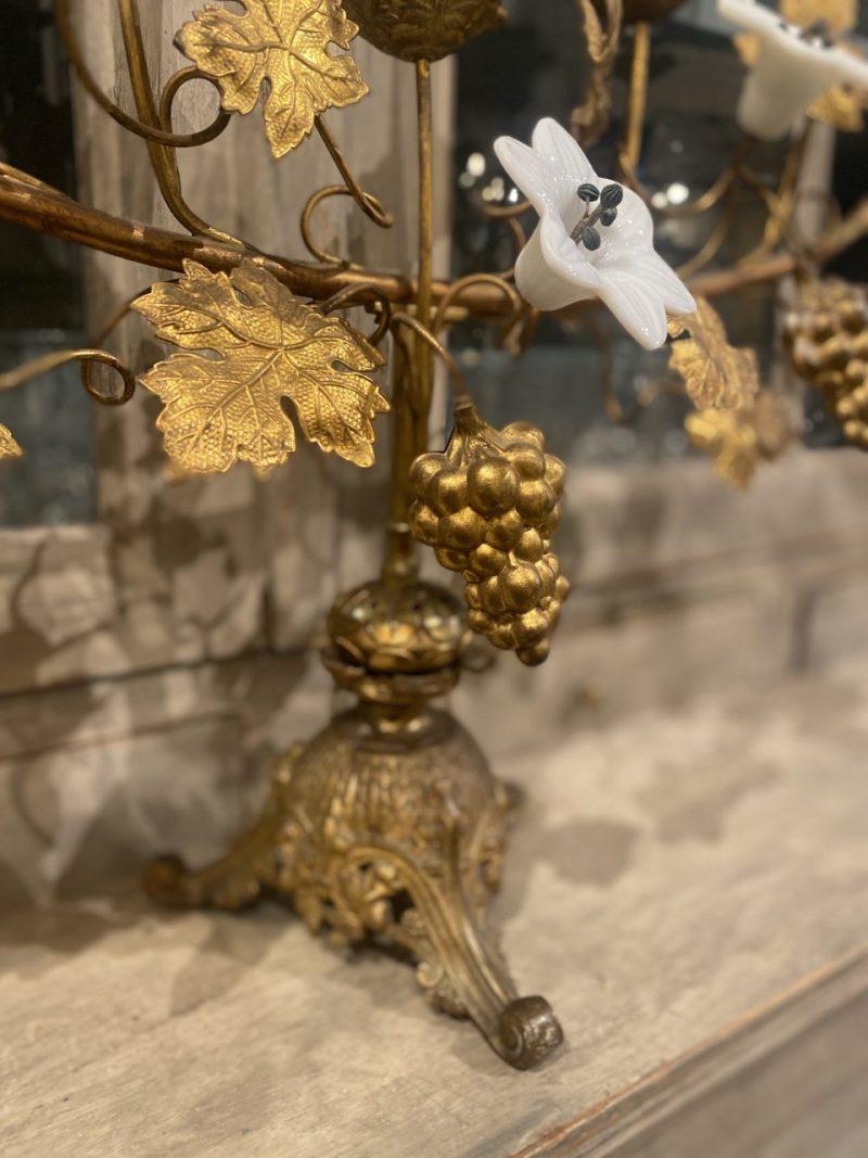 Large and magnificent antique boat-shaped candlestick, beautifully decorated with brass vine leaves and grapes, as well as rare white opaque glass lilies. Gorgeous patina. Charming ornamented base, and elegantly constructed, like a lush flower