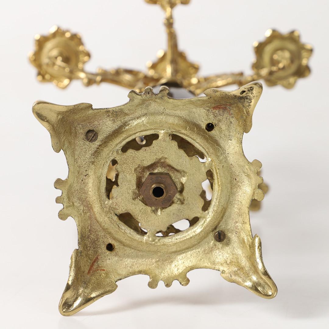 An antique golden brass and black stone, of Rococo-style brass candlestick, pressed, cast and chased. Circular, curved feet with hinged. Tested with the scratch test, height approx. 46cm, diameter 20 cm. All-encompassing C-curves in relief,