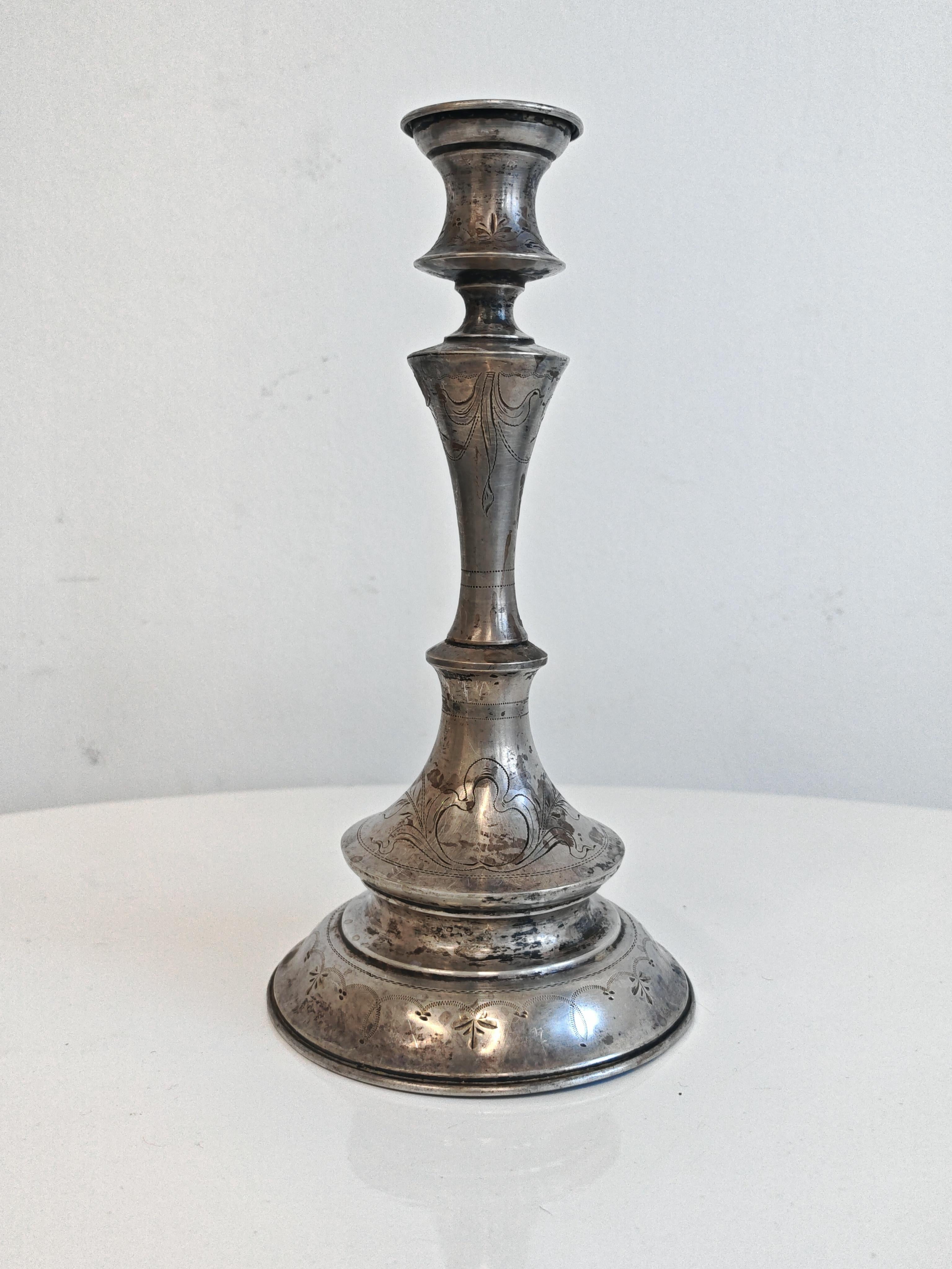 In questa inserzione troverai un bellissimo candeliere in argento con incisioni decorative. Il design è caratterizzato da una base circolare svasata e da uno stelo sagomato a forma di balaustro. Il candeliere è stato realizzato in Austria nel XIX