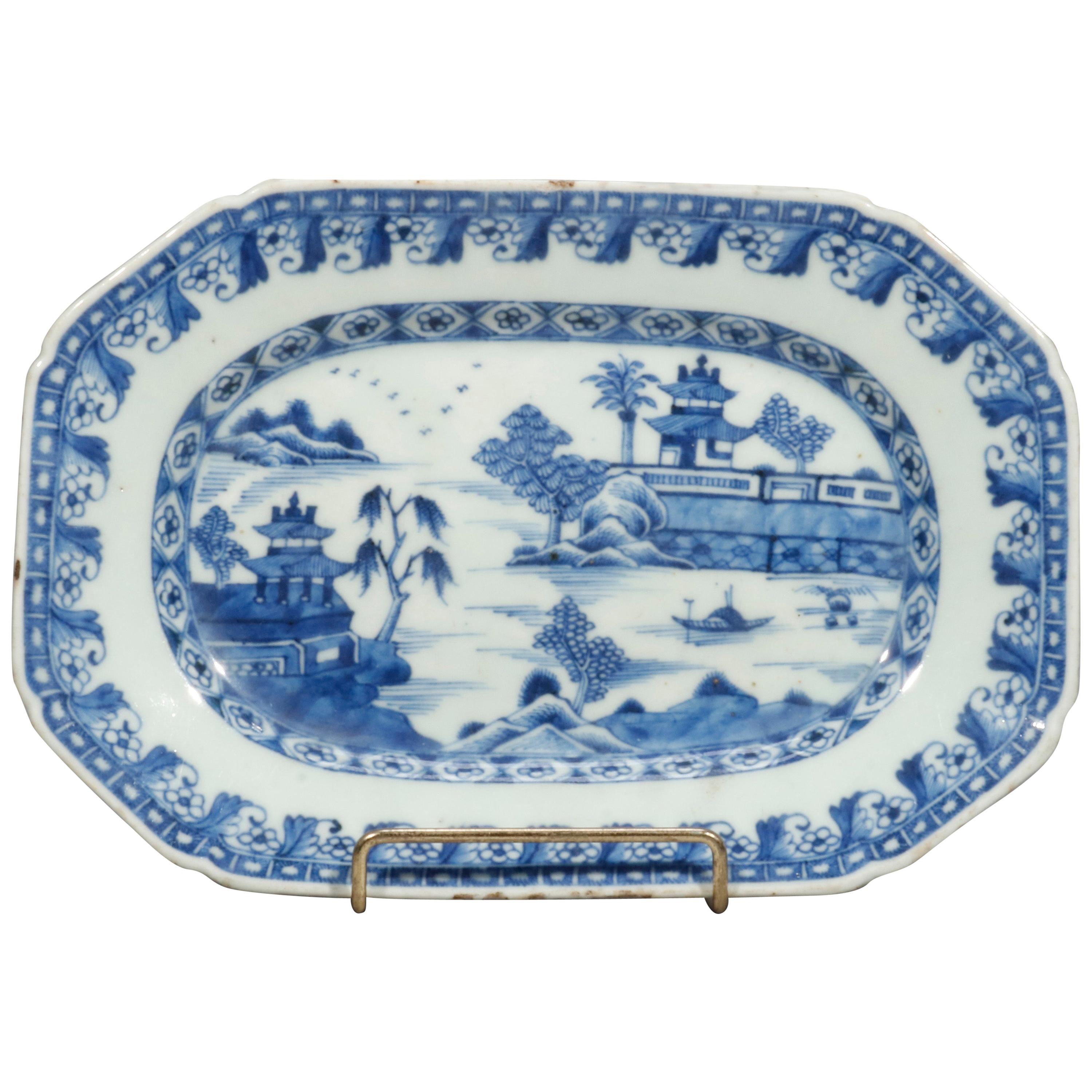 An antique Canton Chinese Export platter offers porcelain construction in rectangular clip-corner form having blue transfer of landscape scene having village elements including pagodas, 19th century.

Measures- 9.88