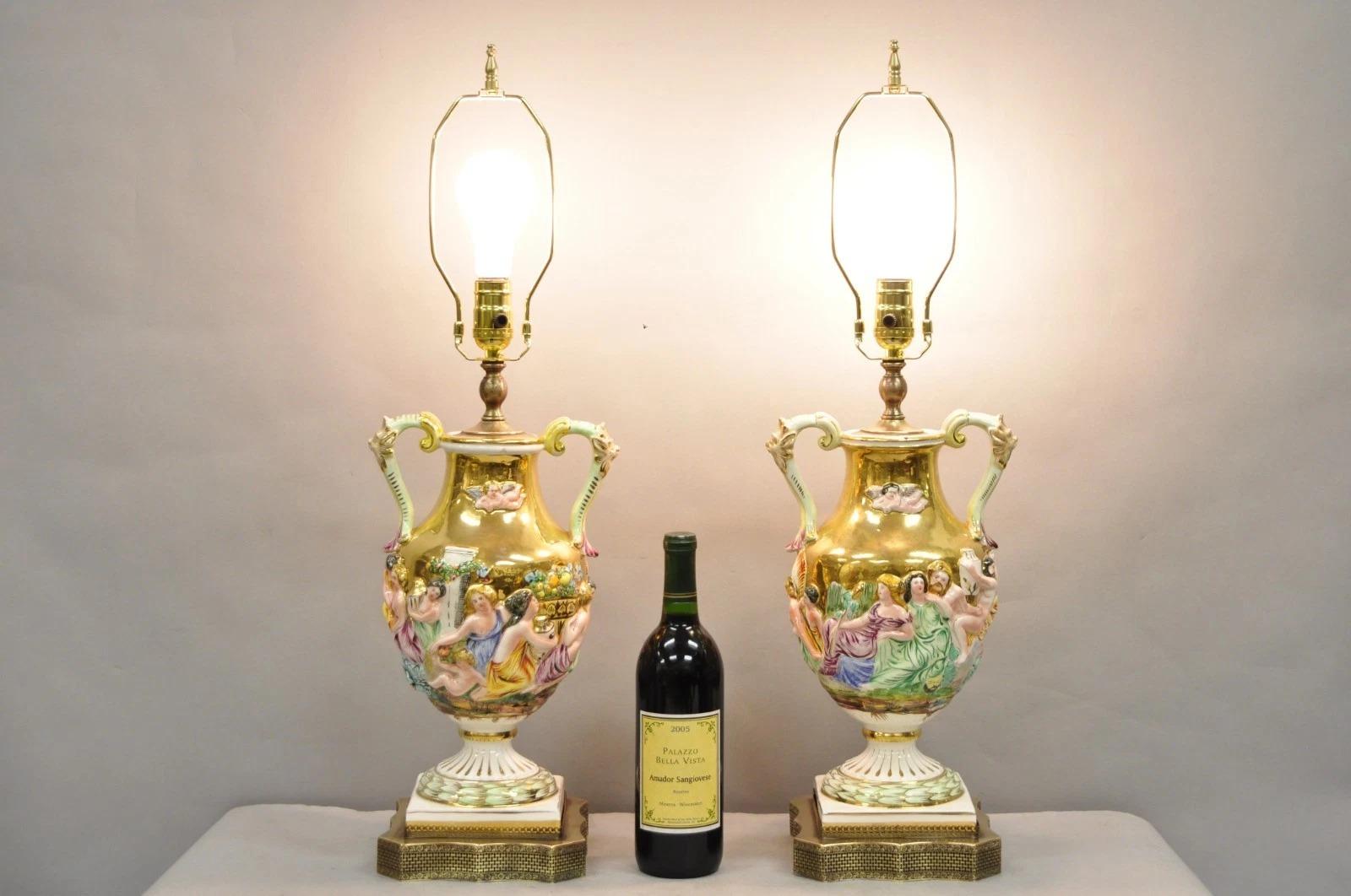 Antique Ialian Capodimonte Figural Porcelain Twin Handle Urn Gold Vase Table Lamps with Classical Scenes of Cherubs, Maidens and Bearded Men - a Pair. Circa Early 20th Century. Measurements: 28