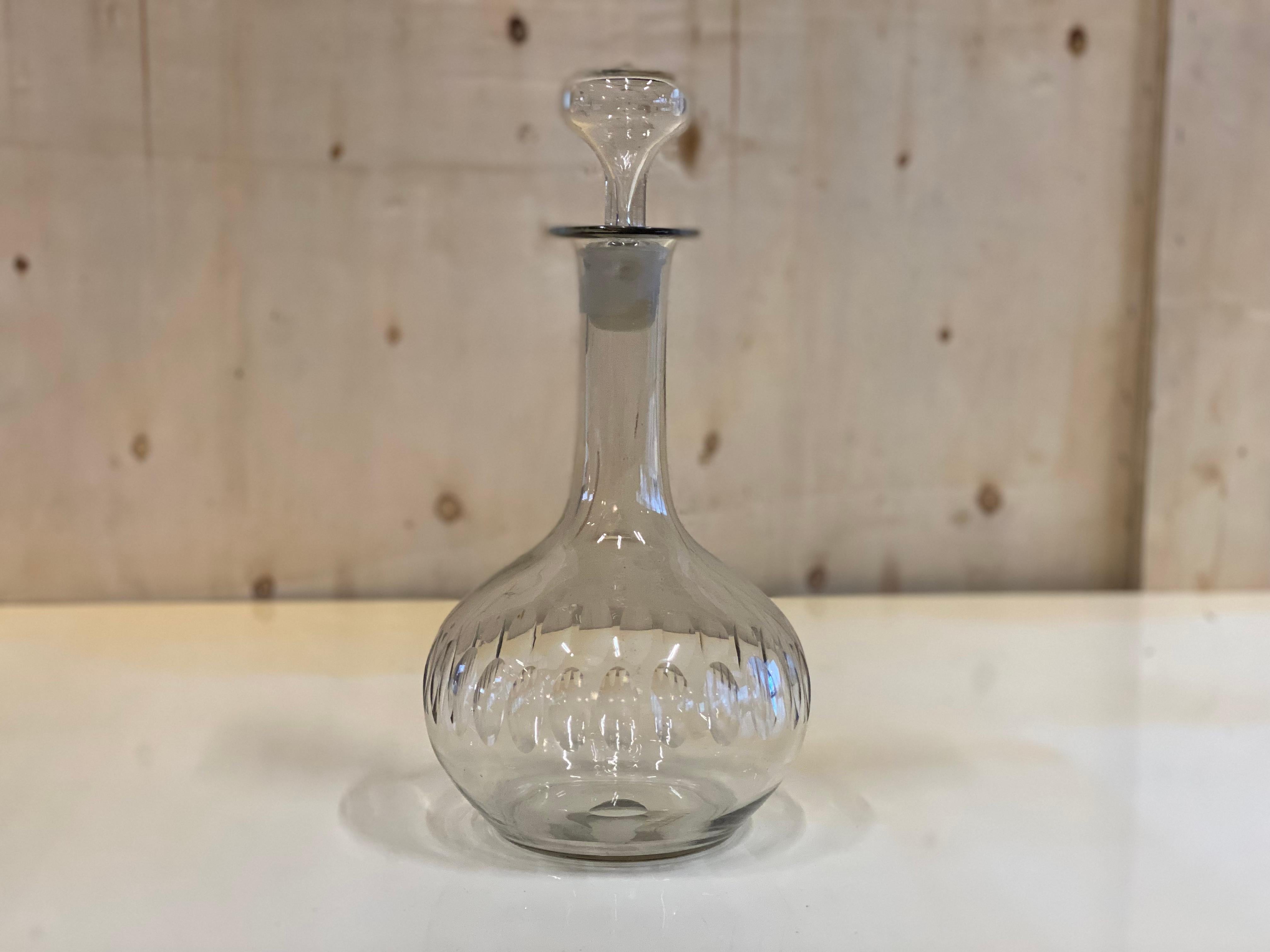 Antique stopper carafe from France from the years around 1900. The carafe has a bulbous body and opens into a narrow neck, which is closed by a stopper. The special feature of the carafe is on the one hand the glass stopper with air inclusion and