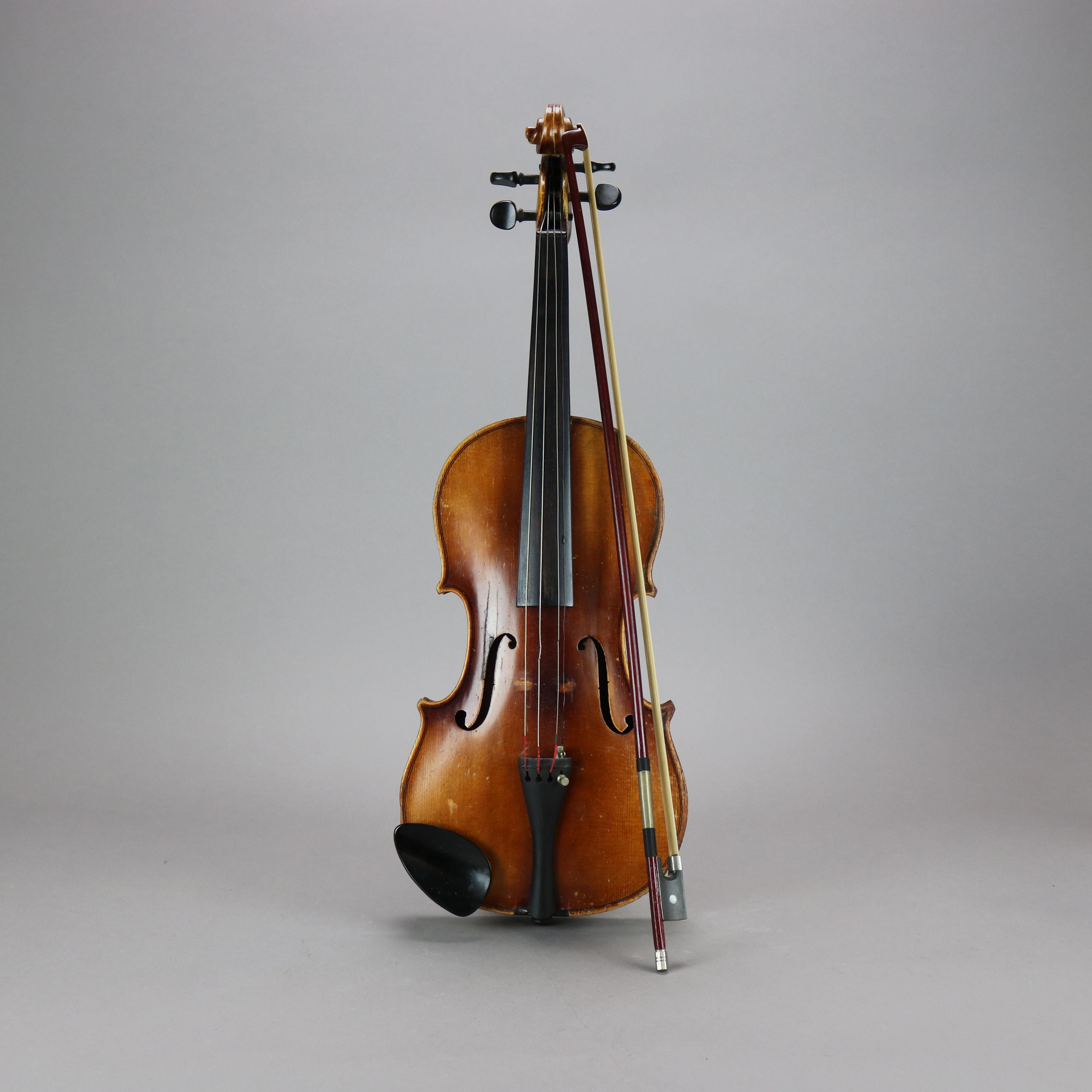 An antique 4/4 full size violin by Carl Meifel, copy of Stradivarius, signed interior, with bow, 20th century

Measures - 3'' H x 8.5'' W x 23'' L.
