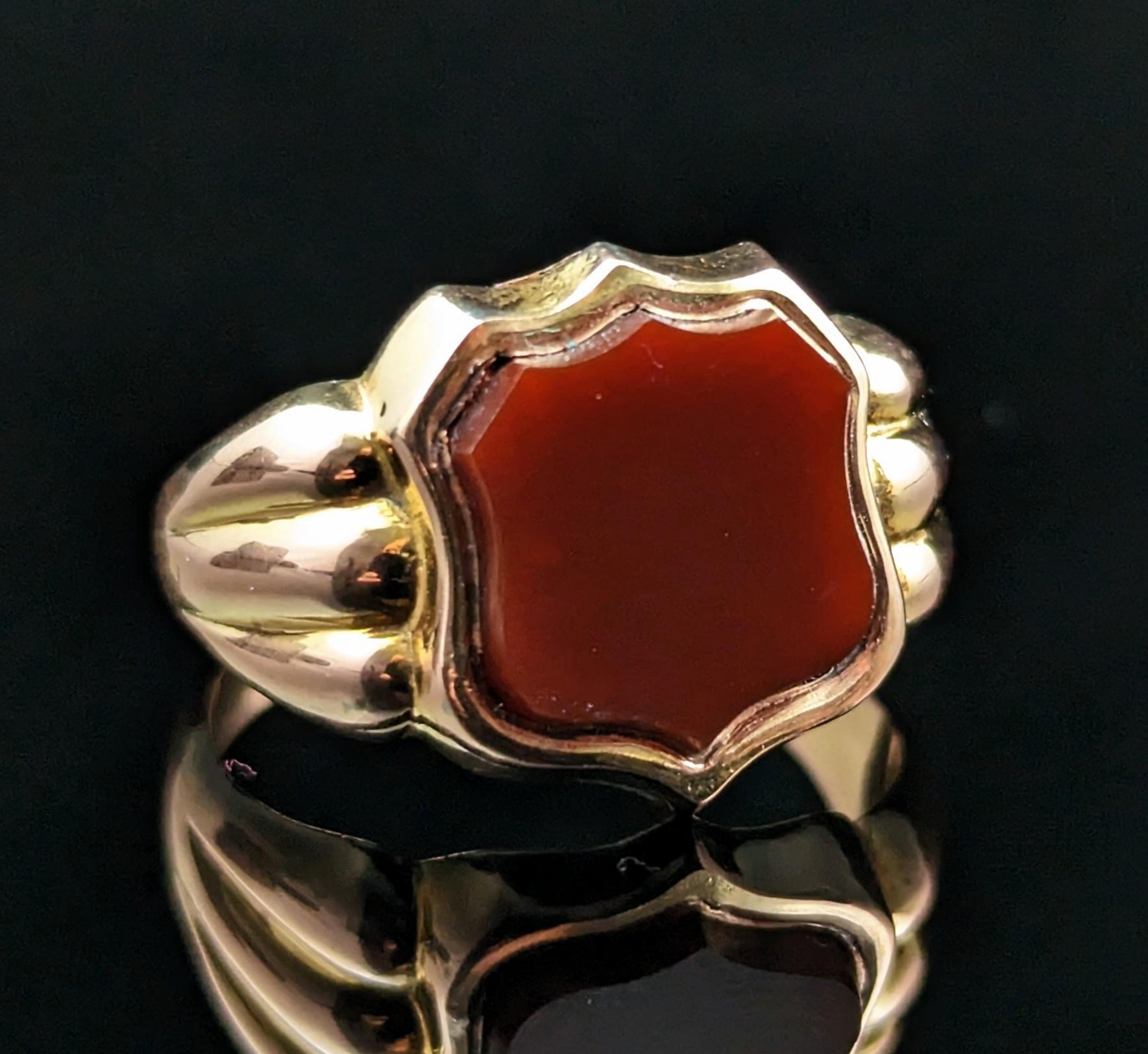 This impeccable antique, Edwardian era
9kt gold and Carnelian signet ring has everything you could wish for in a signet ring!

It has a shield shaped face set with a rich orangey red Carnelian stone, this has not been carved so could be personalised
