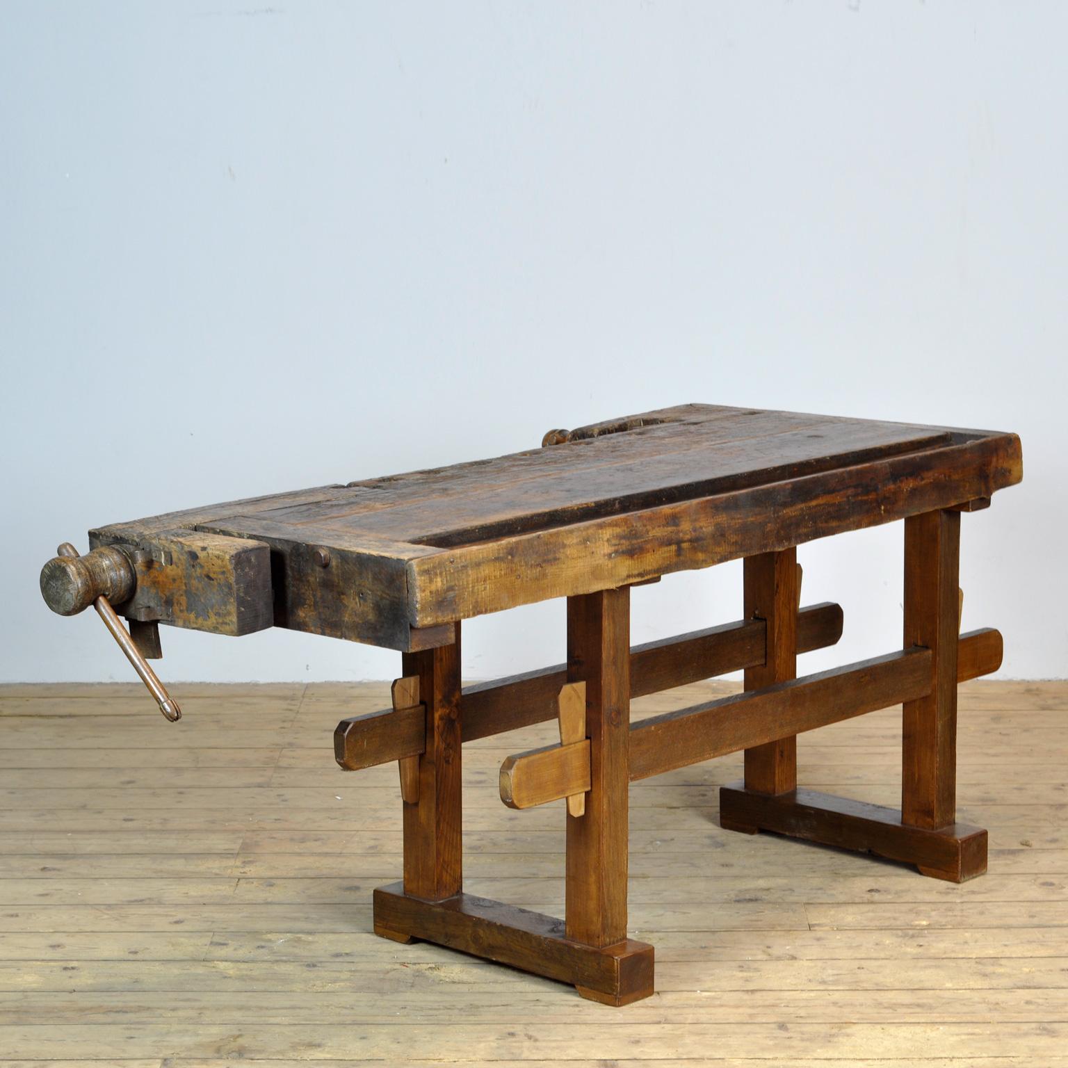 This antique workbench has two built-in wooden vices screws and a recessed tray where the carpenter would put his tools. It was manufactured around 1930. Made from oak. Beautiful patina after years of use. The workbench has been treated for