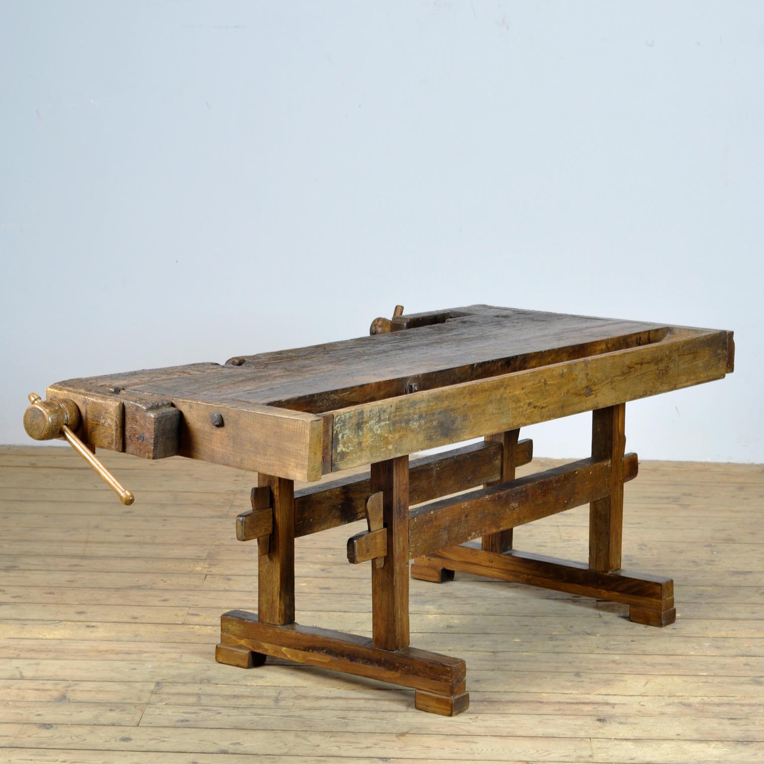 This antique workbench has two built-in wooden vices screws and a recessed tray where the carpenter would put his tools. It was manufactured around 1910. Made from oak. Beautiful patina after years of use. The workbench has been treated for