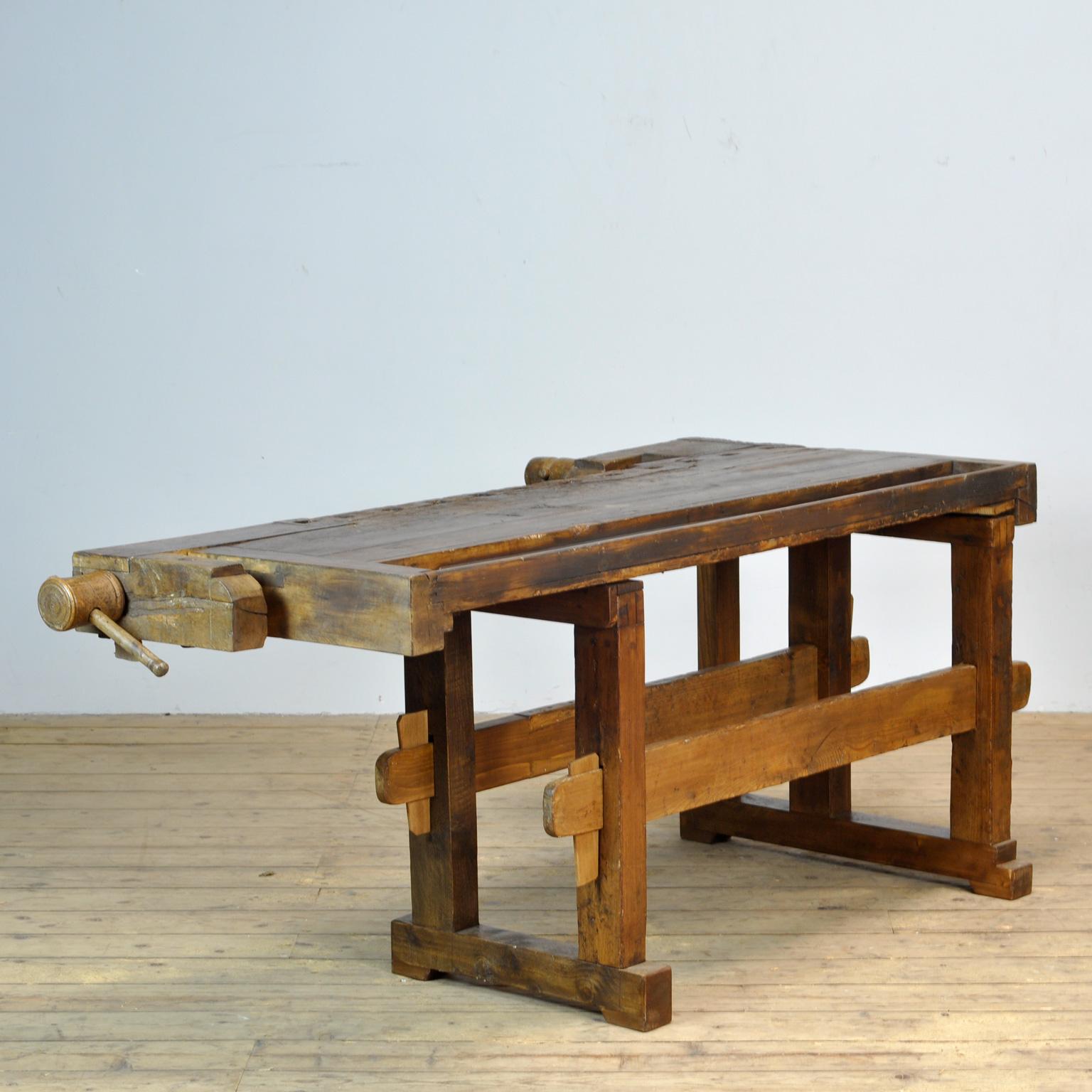 This antique workbench has two built-in wooden vices screws and a recessed tray where the carpenter would put his tools. It was manufactured around 1910. Made from oak. Beautiful patina after years of use. The workbench has been treated for