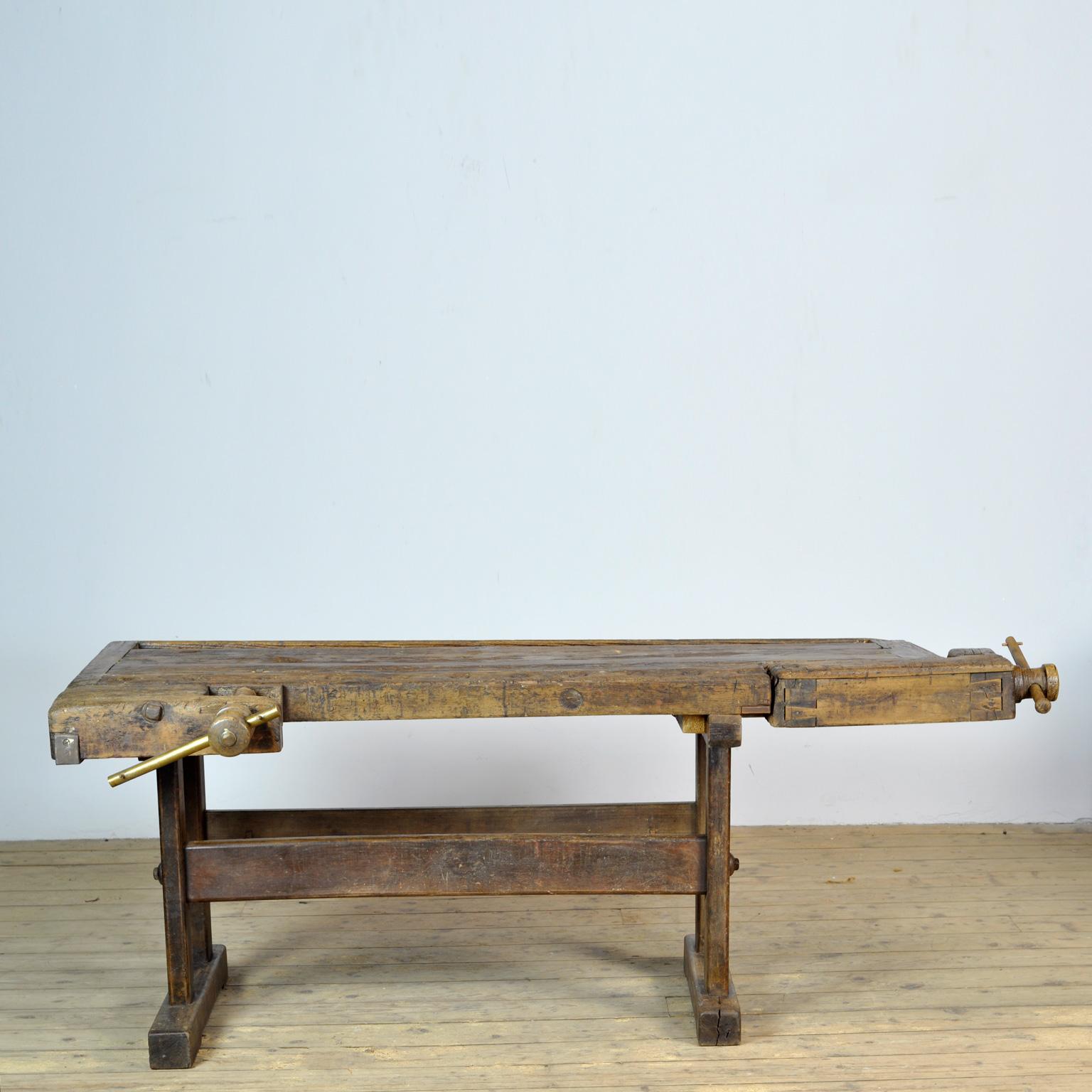 This antique workbench has two built-in wooden vices screws and a recessed tray where the carpenter would put his tools. It was manufactured around 1910. Made from oak. Beautiful patina after years of use. The workbench has been treated for